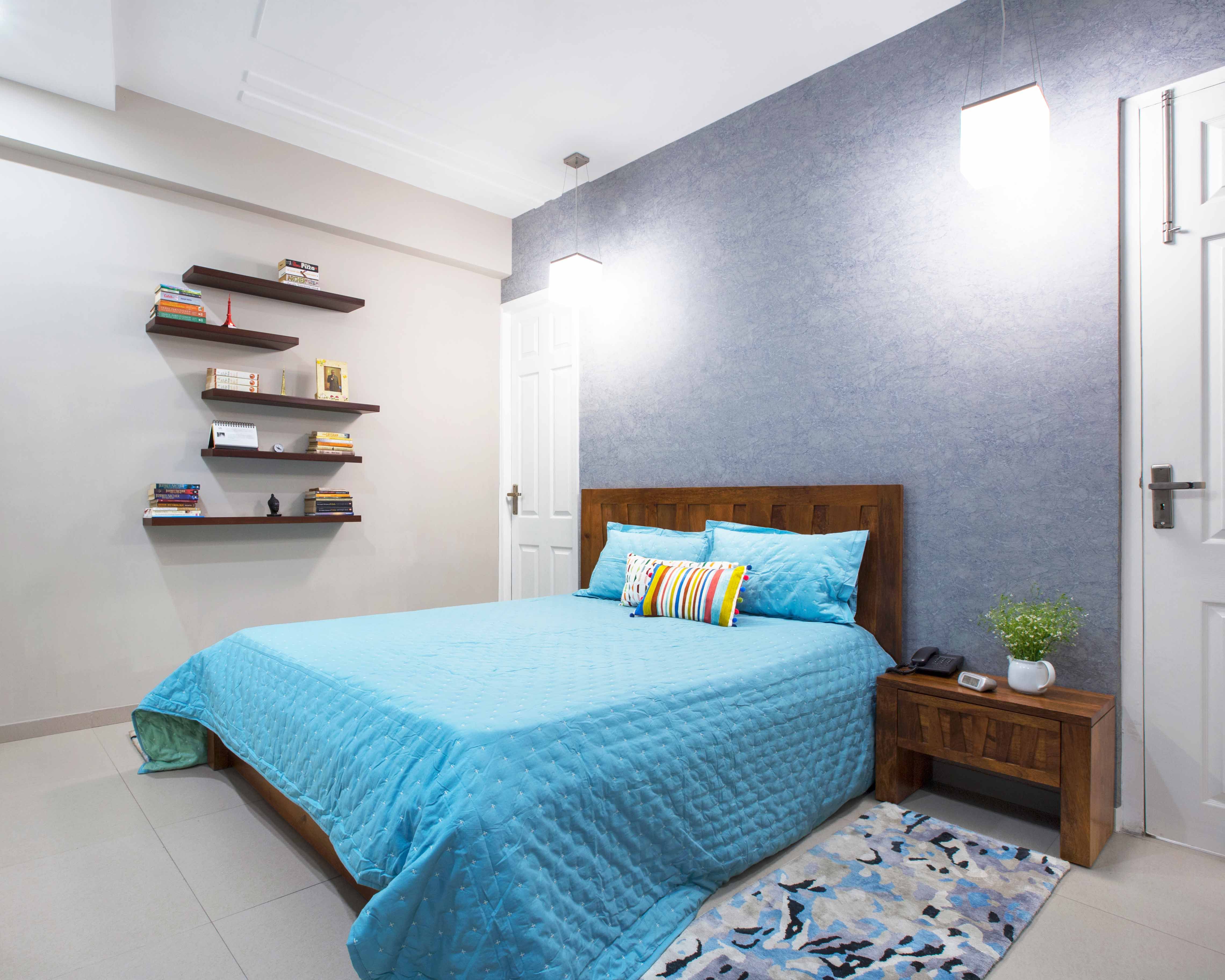 Modern Blue Guest Bedroom Design With Wooden Headboard And Wall-Mounted Shelves