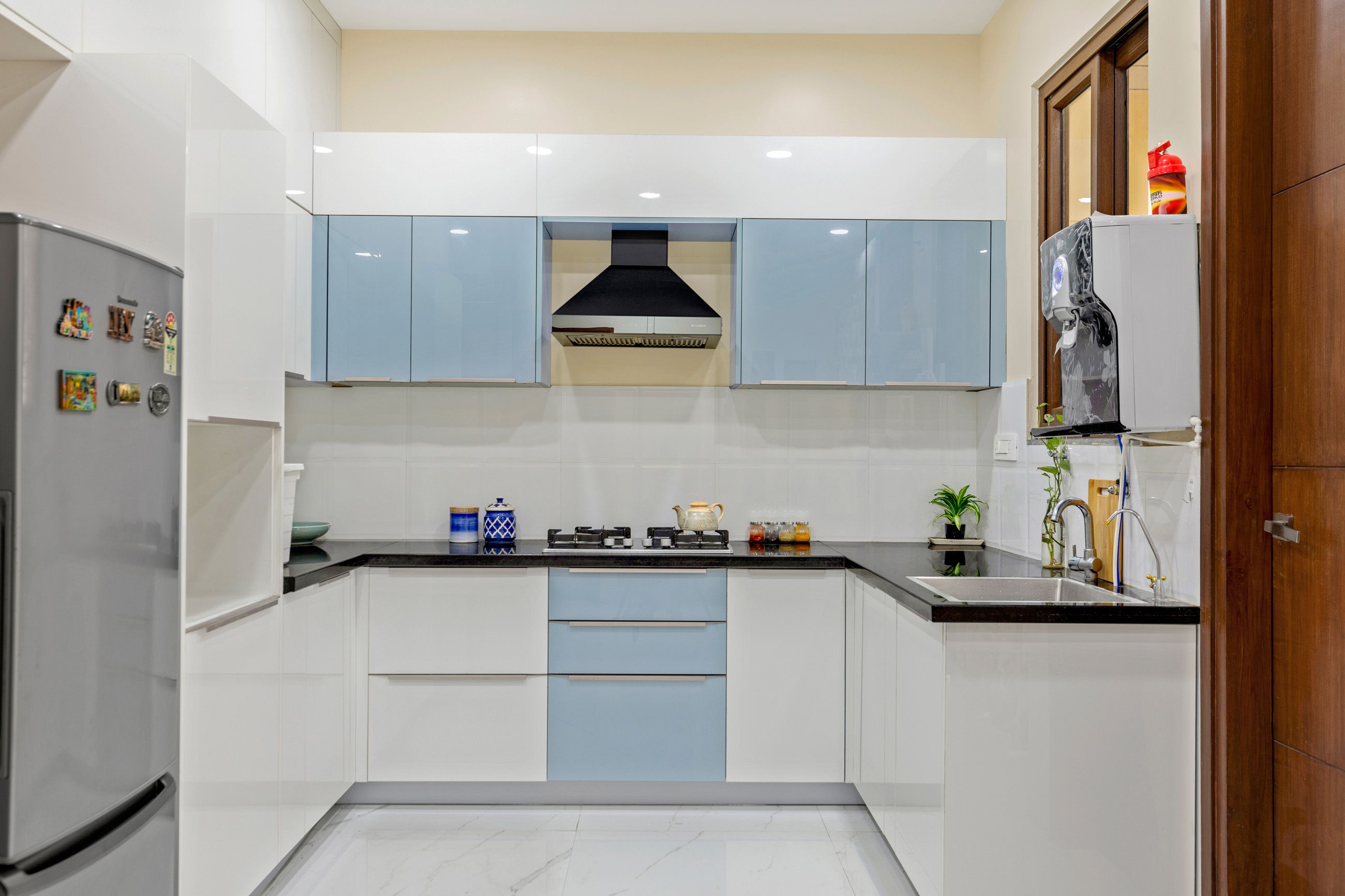 Contemporary 3-BHK Interior Design In Hyderabad With U-Shaped Blue And White Glossy Kitchen