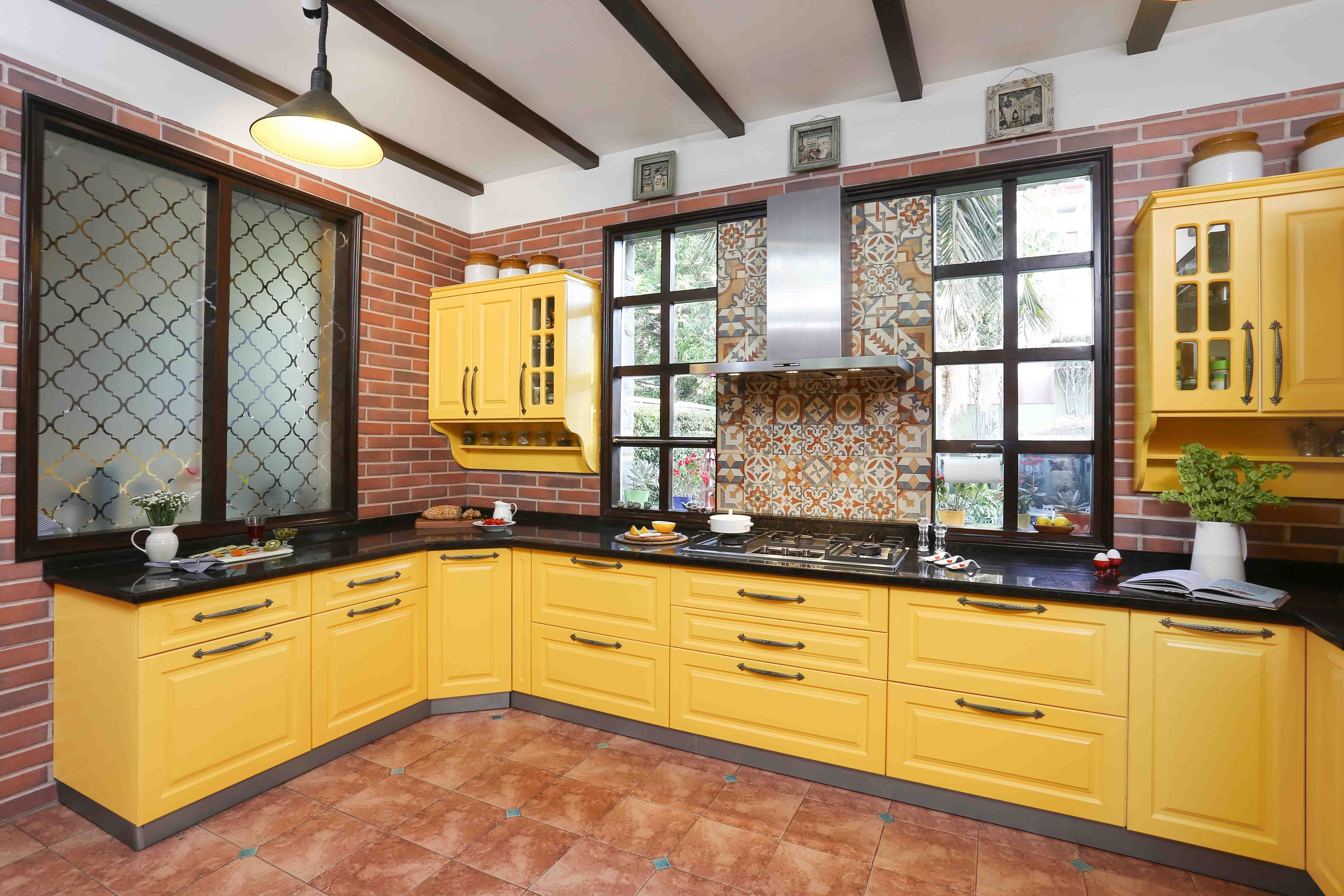 Transitional U-Shaped Kitchen Cabinet Design With Yellow Cabinets And Red Brick Accent Wall