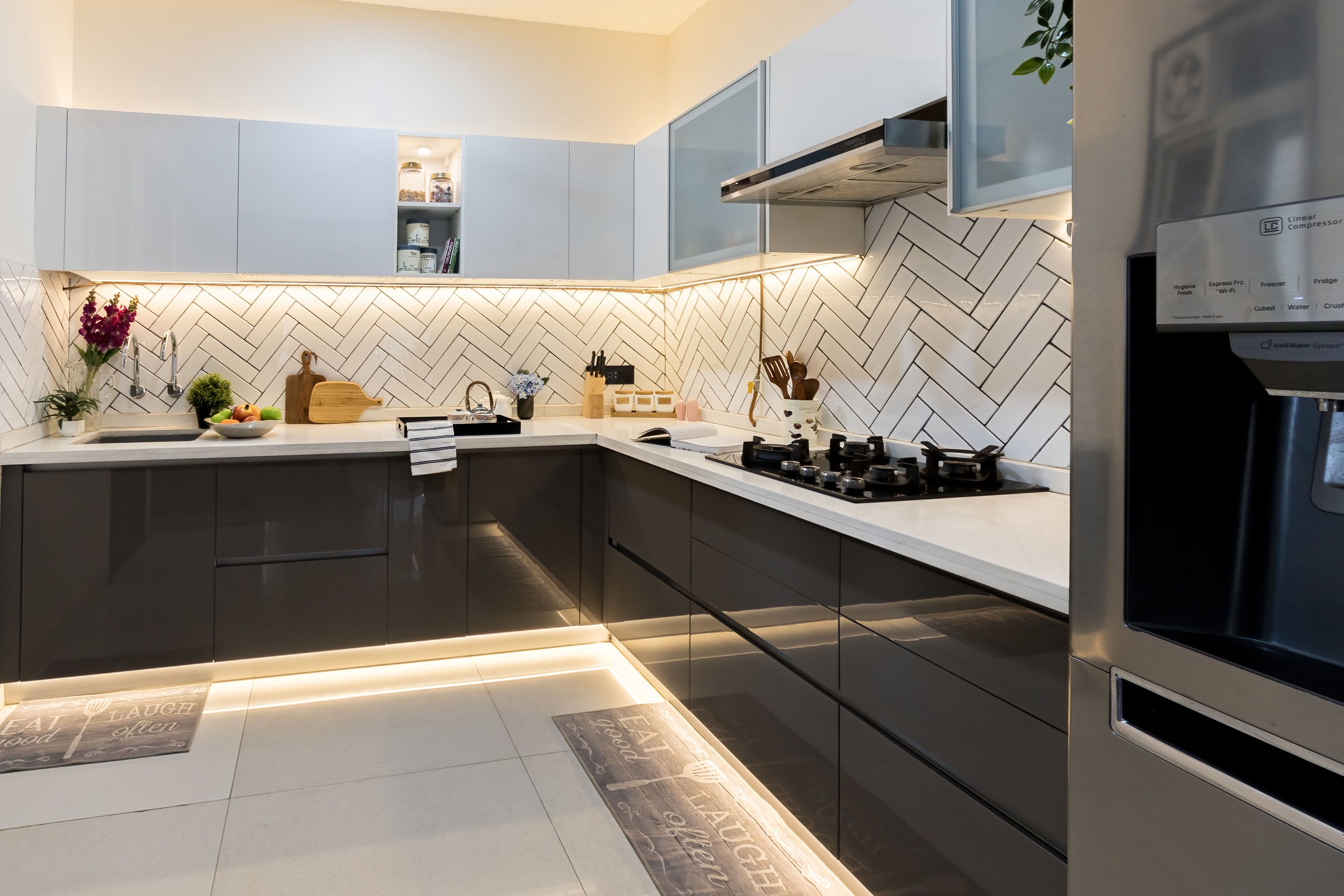 Modern L Shaped Kitchen Design With Seamless High Gloss Finish And Elegant Herringbone Backsplash