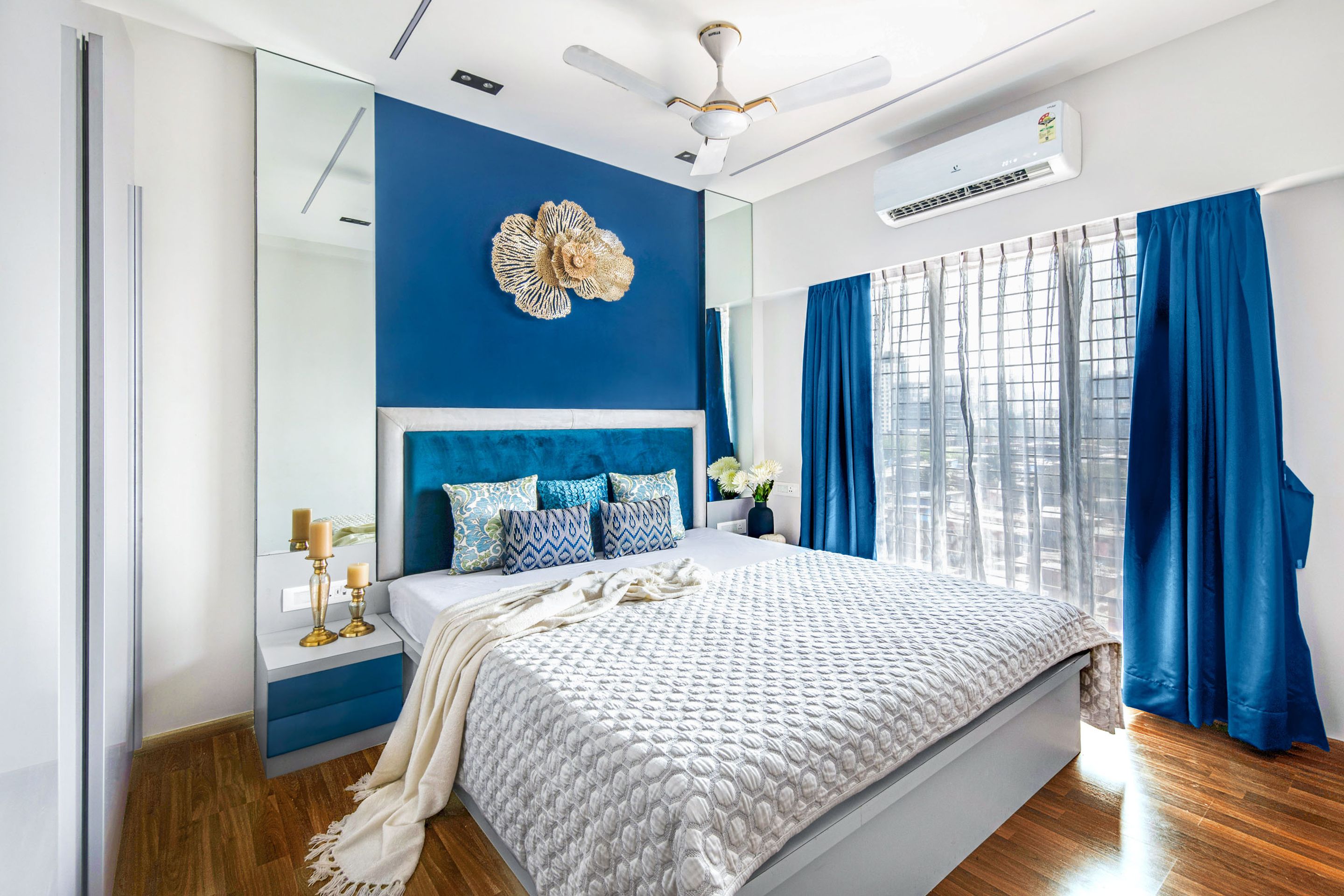 Blue And White Master Bedroom Design With Gold Floral Wall Decor | Livspace