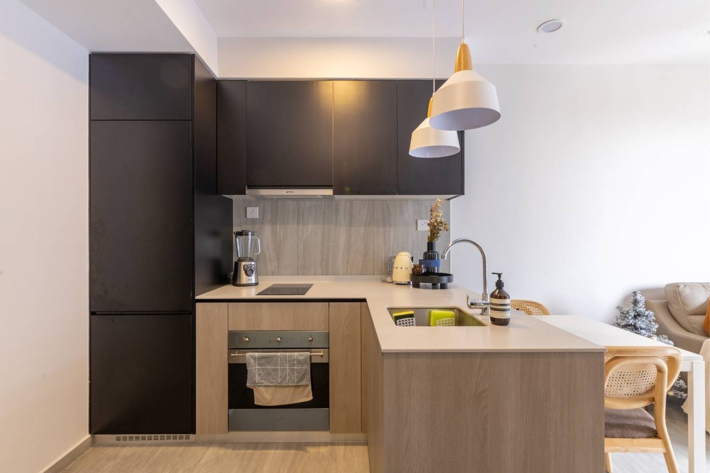 Compact L-Shaped Kitchen in Wood with Black Tall Unit and Wall Storage - Livspace