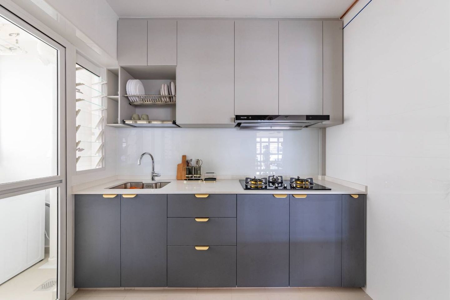 Compact Straight Kitchen with Dark Grey Floor Cabinets, Light Grey Wall Cabinets, Gold Handles, and White Countertop - Livspace
