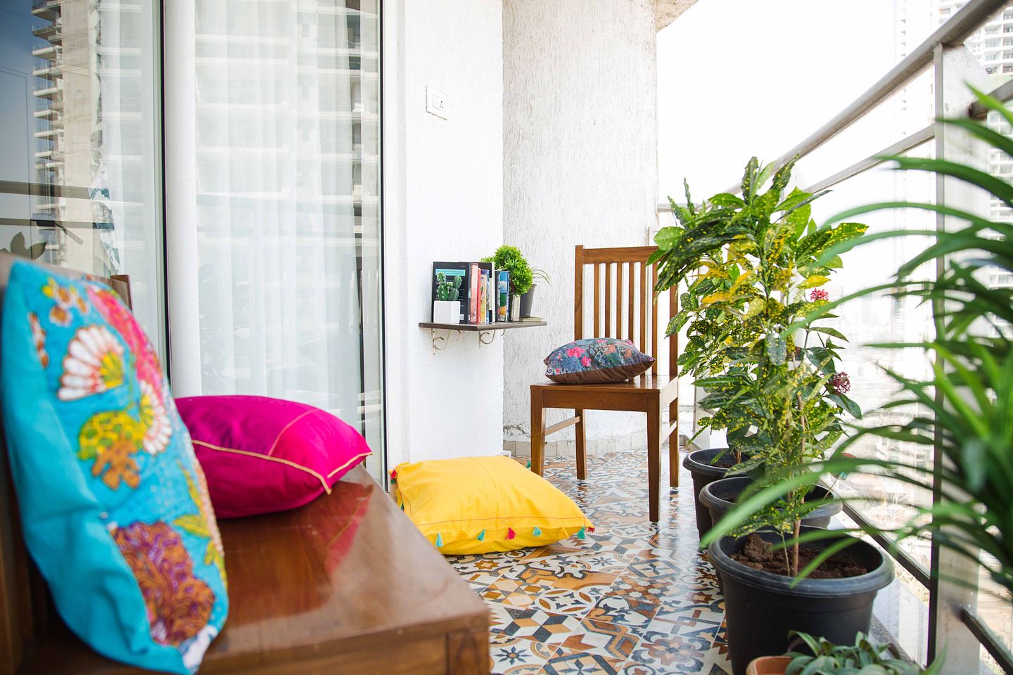 Eclectic Balcony Design with Textured Off-White Wall, Moroccan Floor Tiling, and Colorful Cushioned Wooden Seater - Livspace