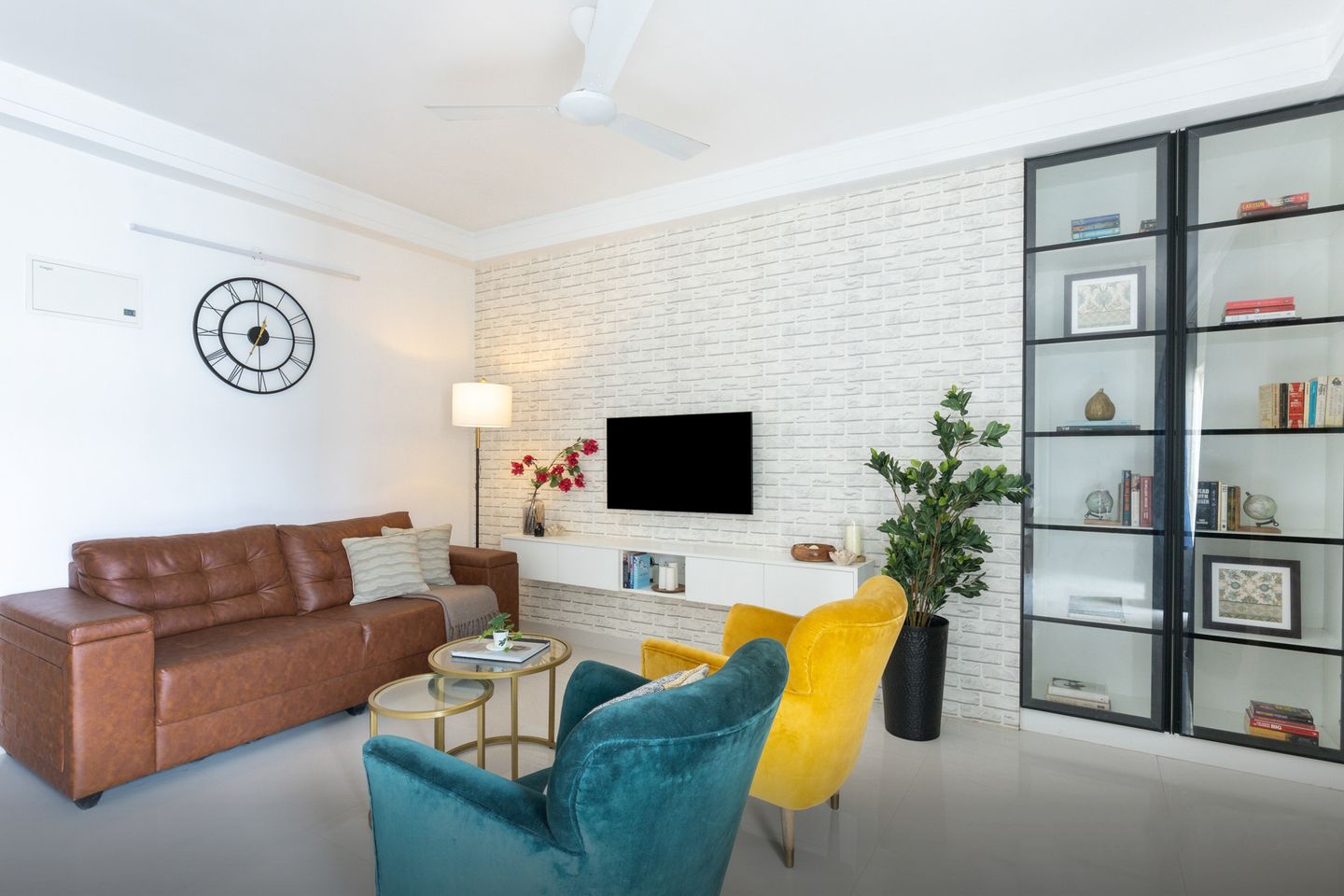 Large white living room design with white brick wall and accent chairs - Livspace