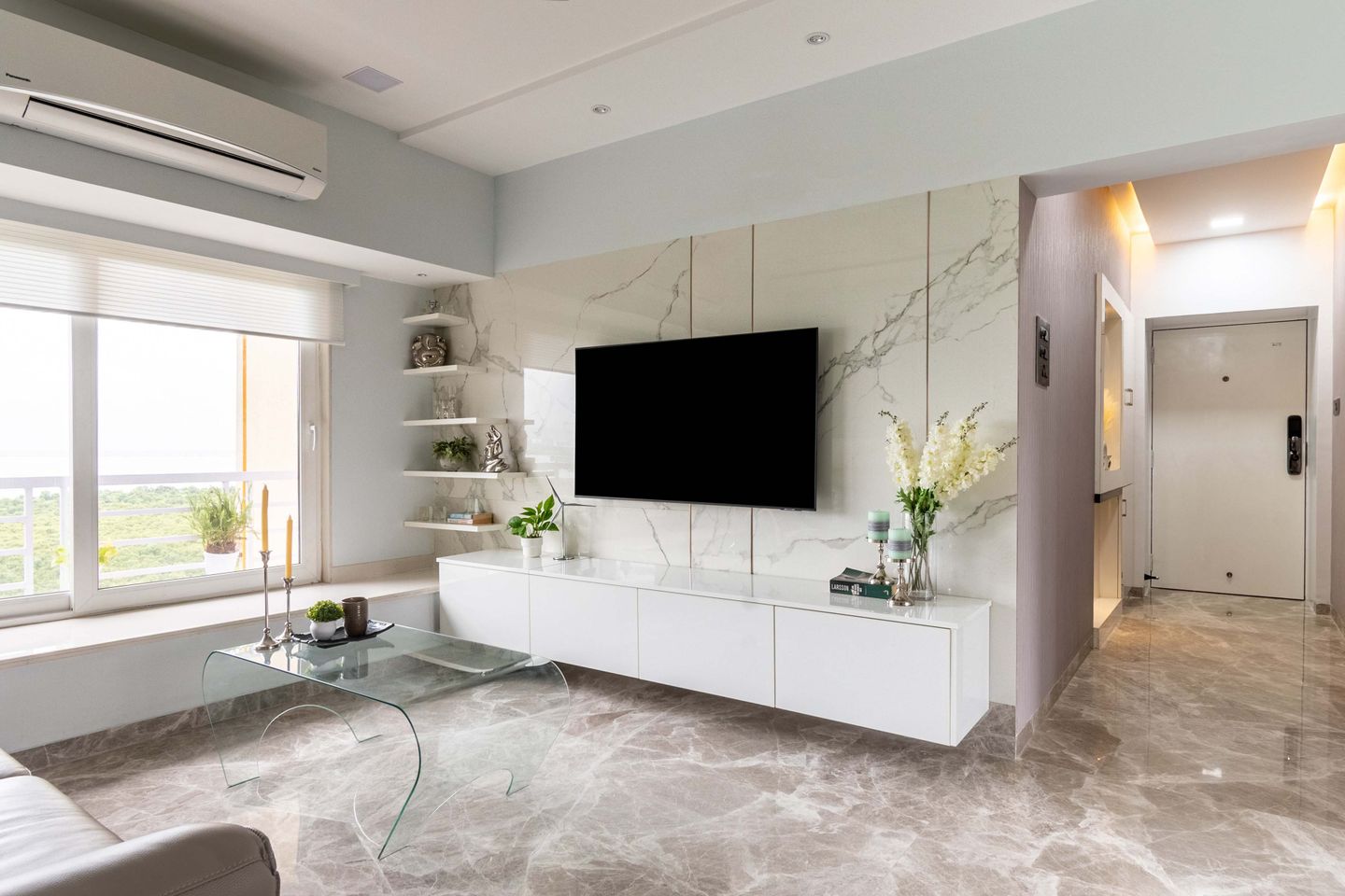 Living room with light coloured TV unit with marble back panel - Livspace
