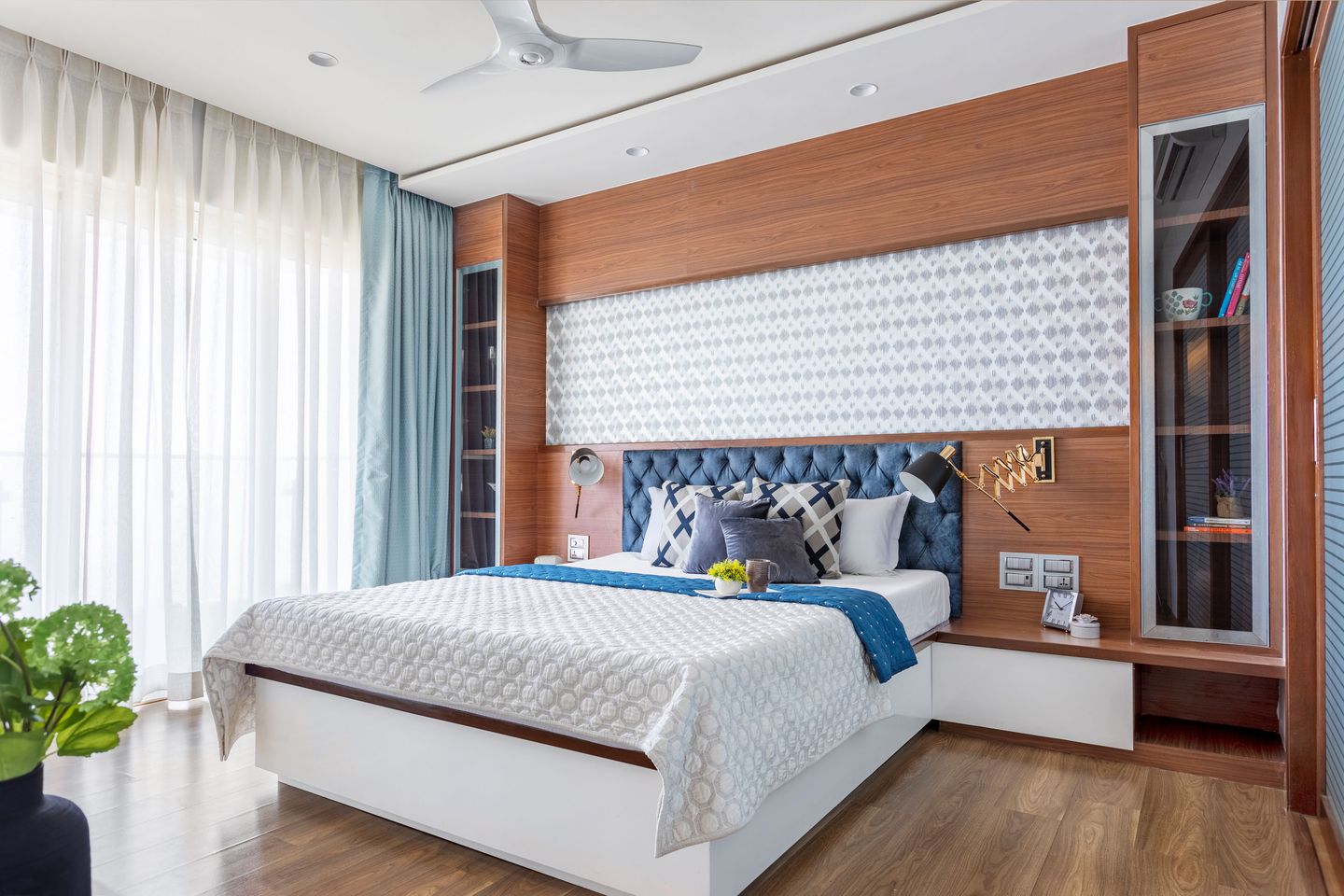 Bedroom Design With Wooden Interiors And Bed With Blue Headboard - Livspace