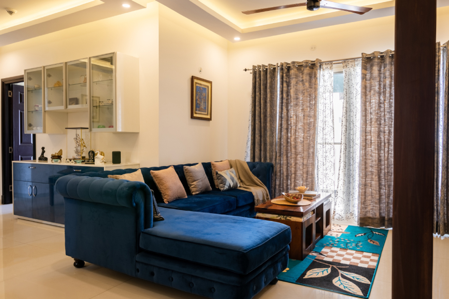 Living Room With A Blue Sectional Sofa And A Wooden Center Table - Livspace