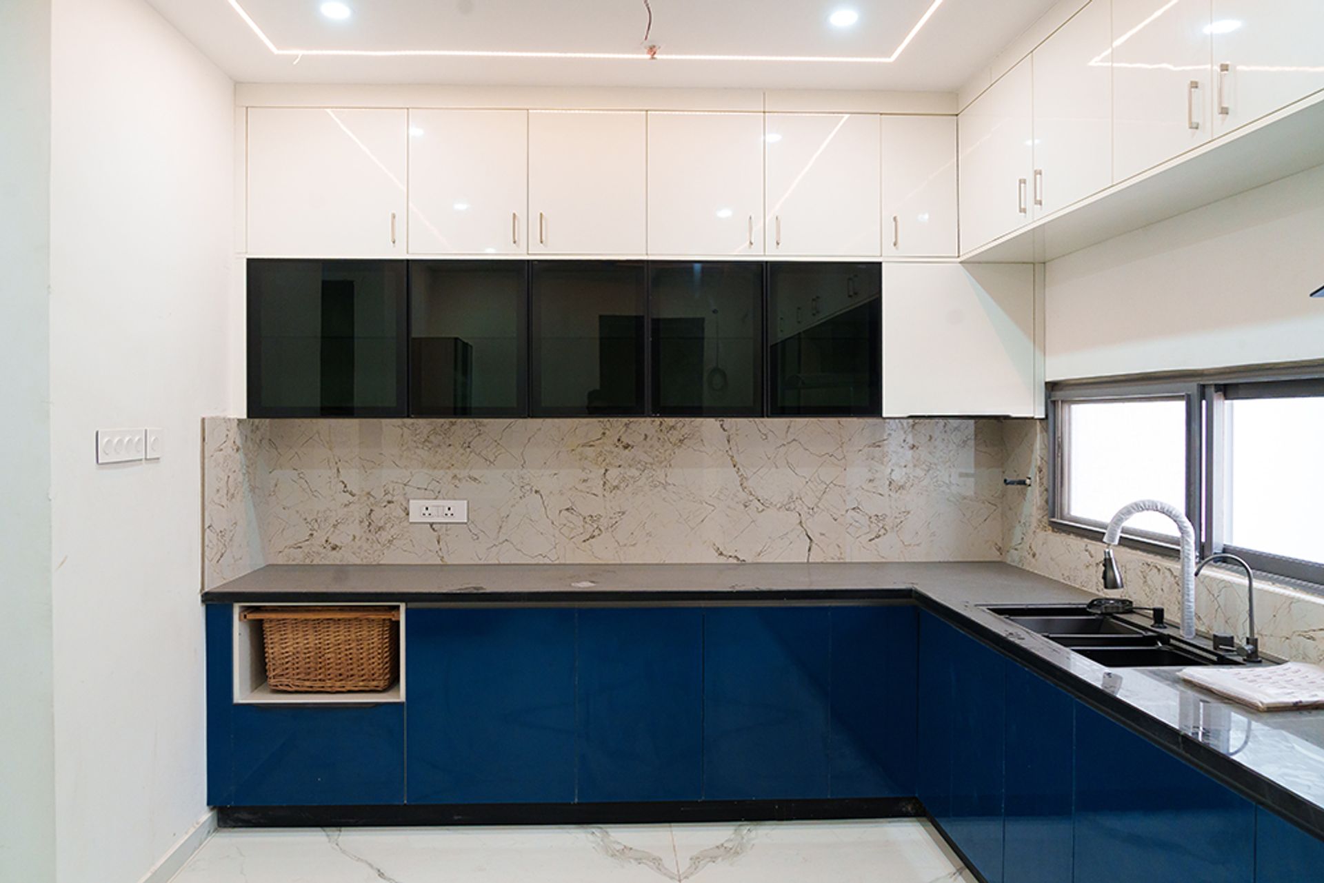 Modern L-Shaped Kitchen Design With Blue Cabinets and Marble Top | Livspace