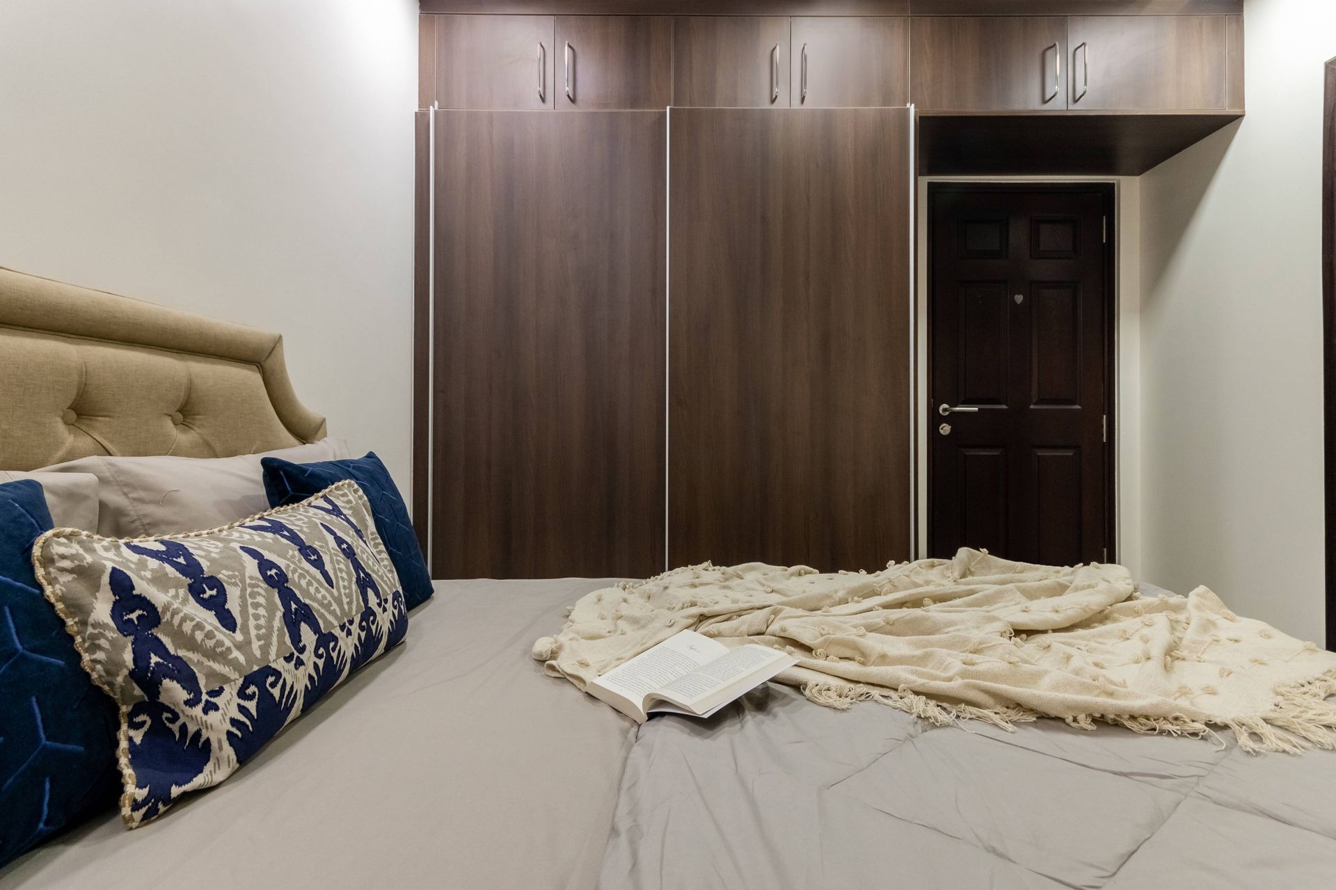 Spacious Guest Bedroom Design With Beige Tufted Headboard | Livspace