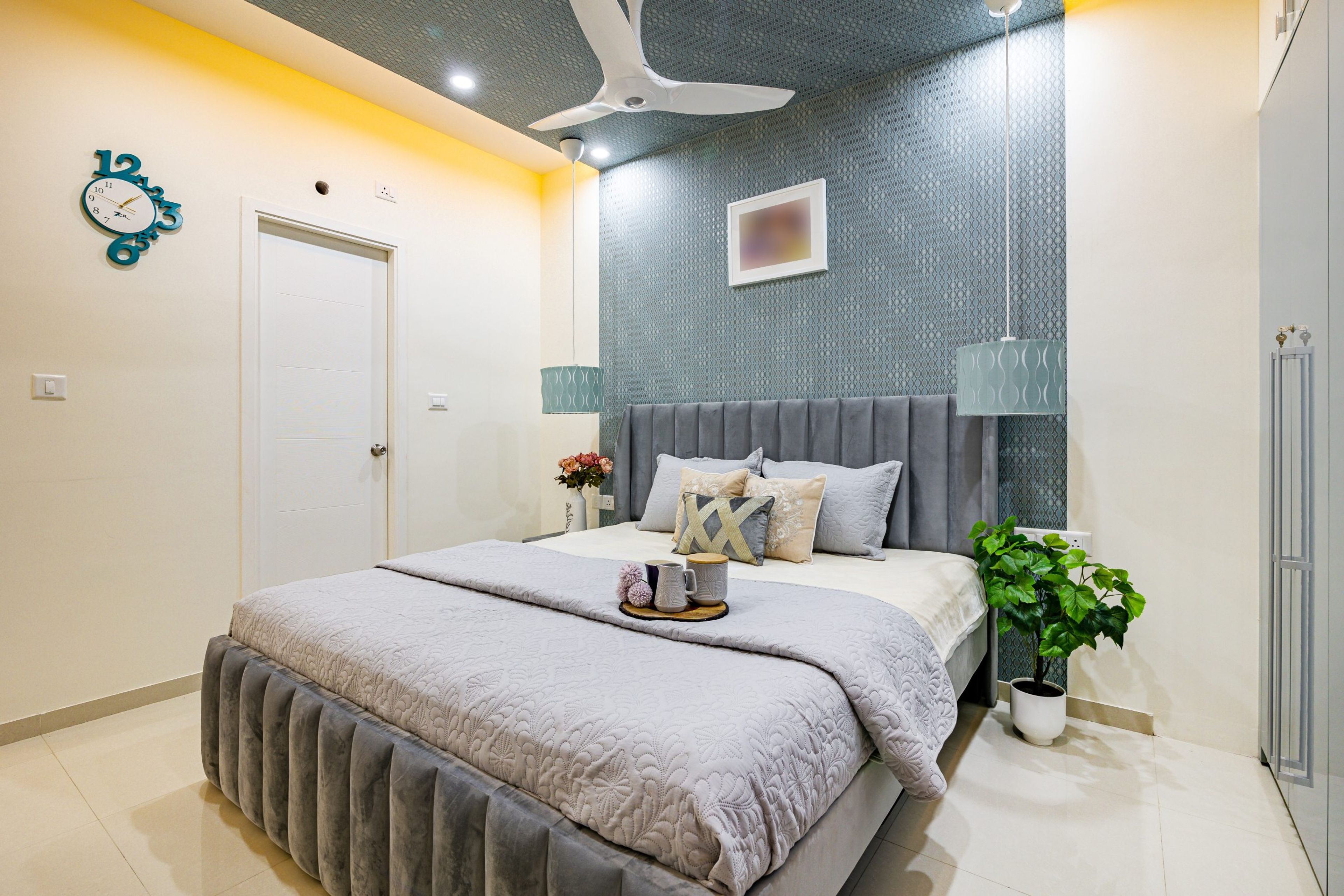 Gypsum false ceiling with warm cove lighting and pendant lights in a room - Livspace