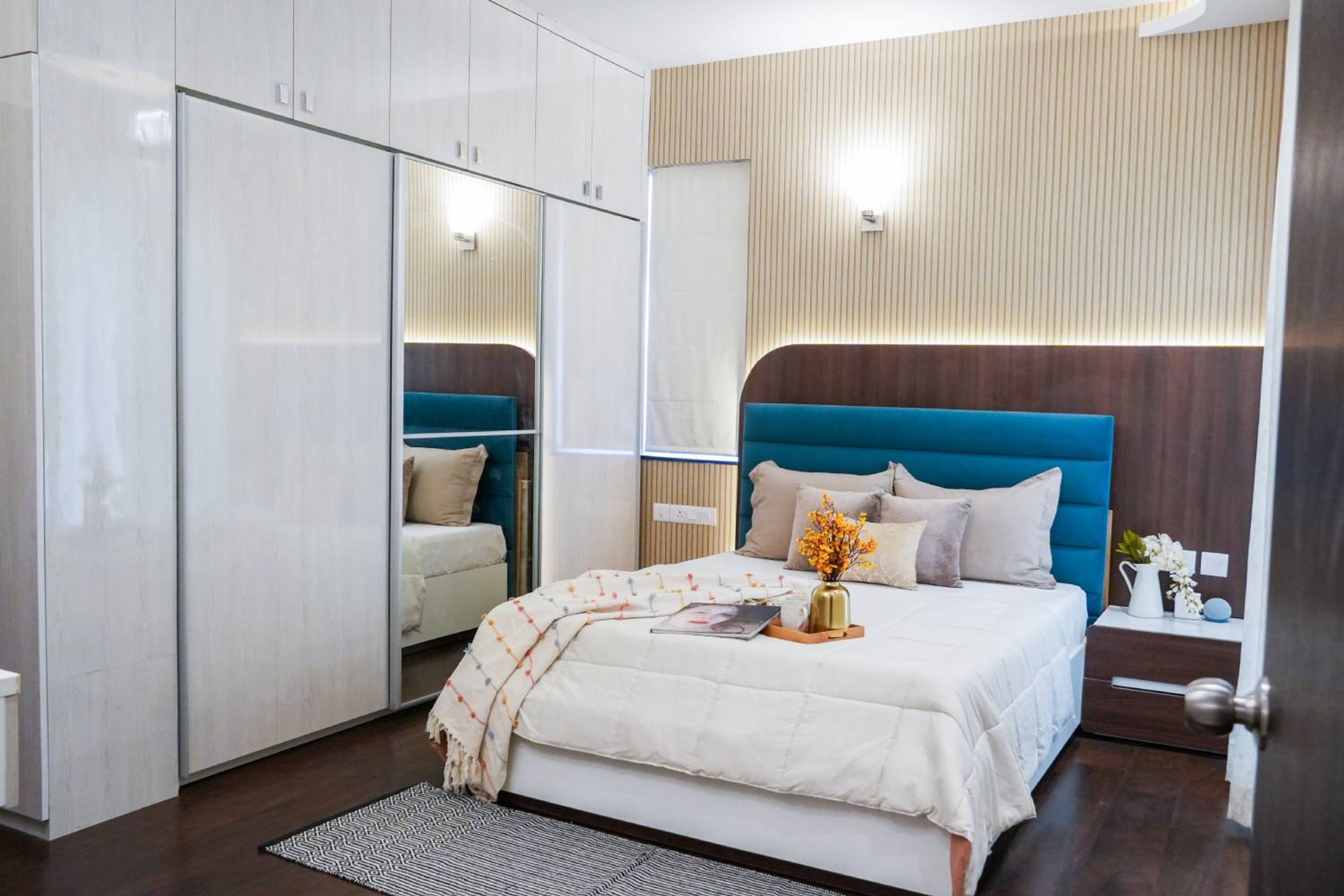 Master Bedroom Design with Fluted Beige Wall and White Sliding Wardrobe with Integrated Mirror