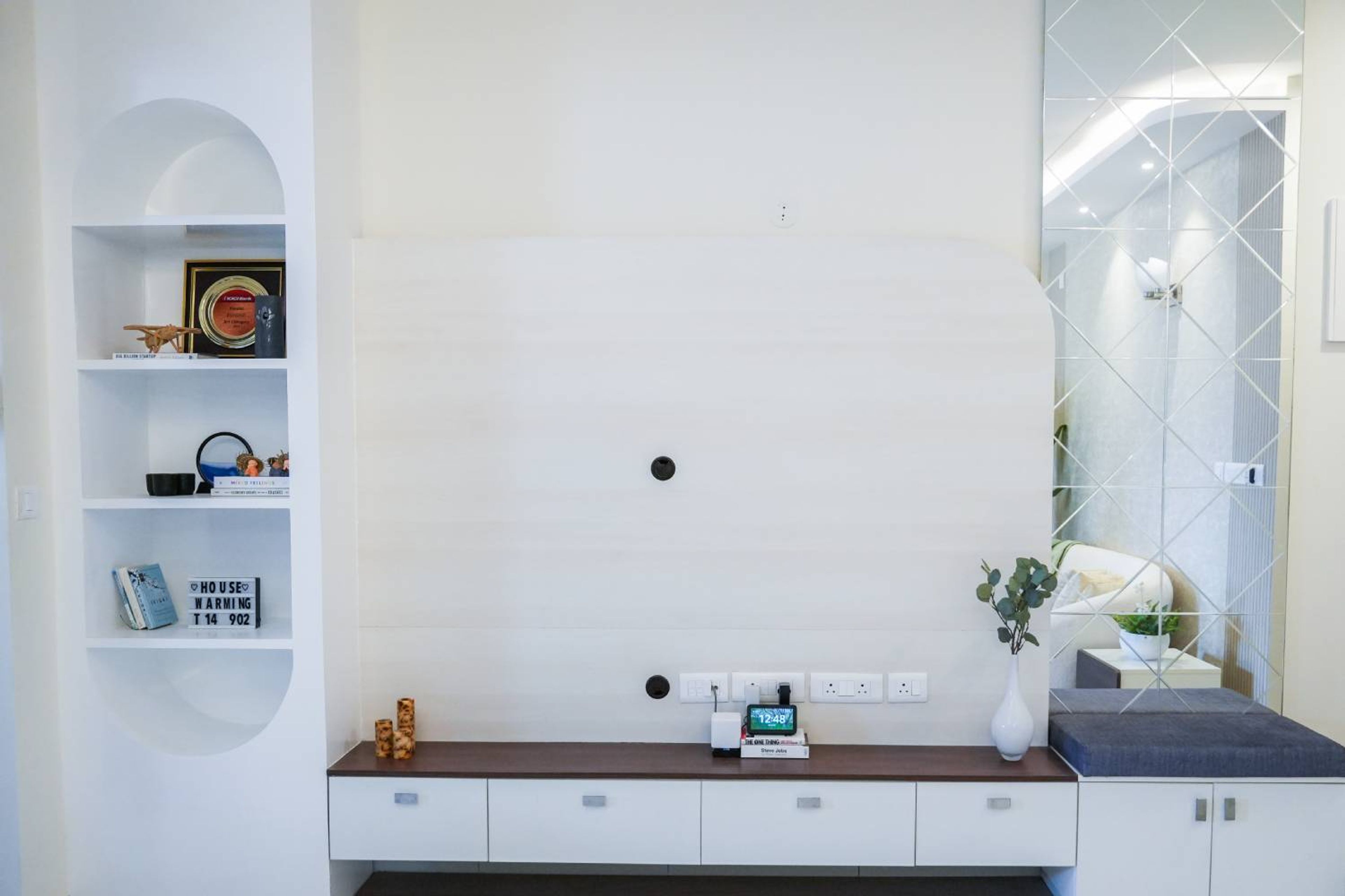 TV Unit Design with White Wooden Backsplash and Geometric Mirror