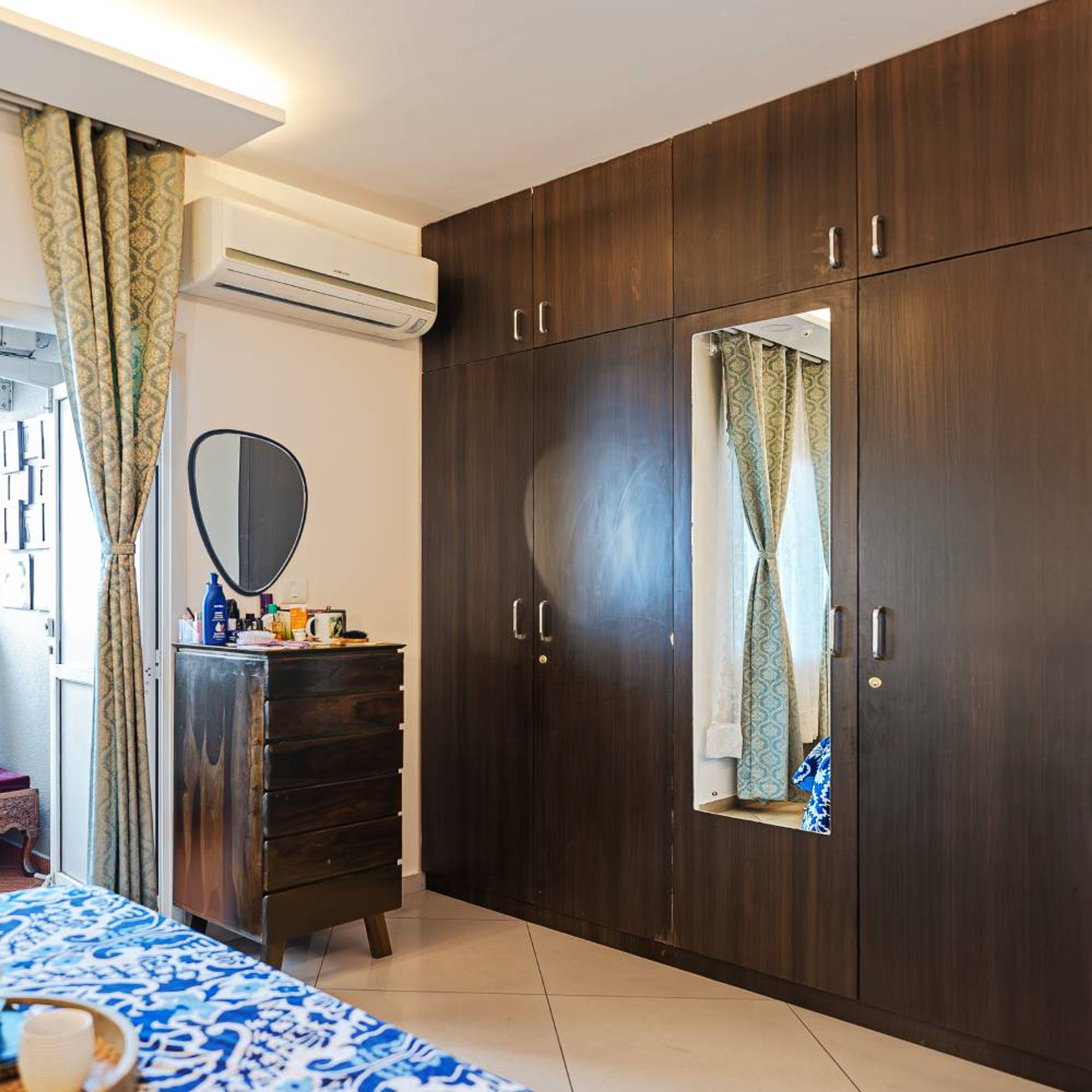 Dark wooden 4-door swing wardrobe with central mirror, overhead storage, and matching dresser