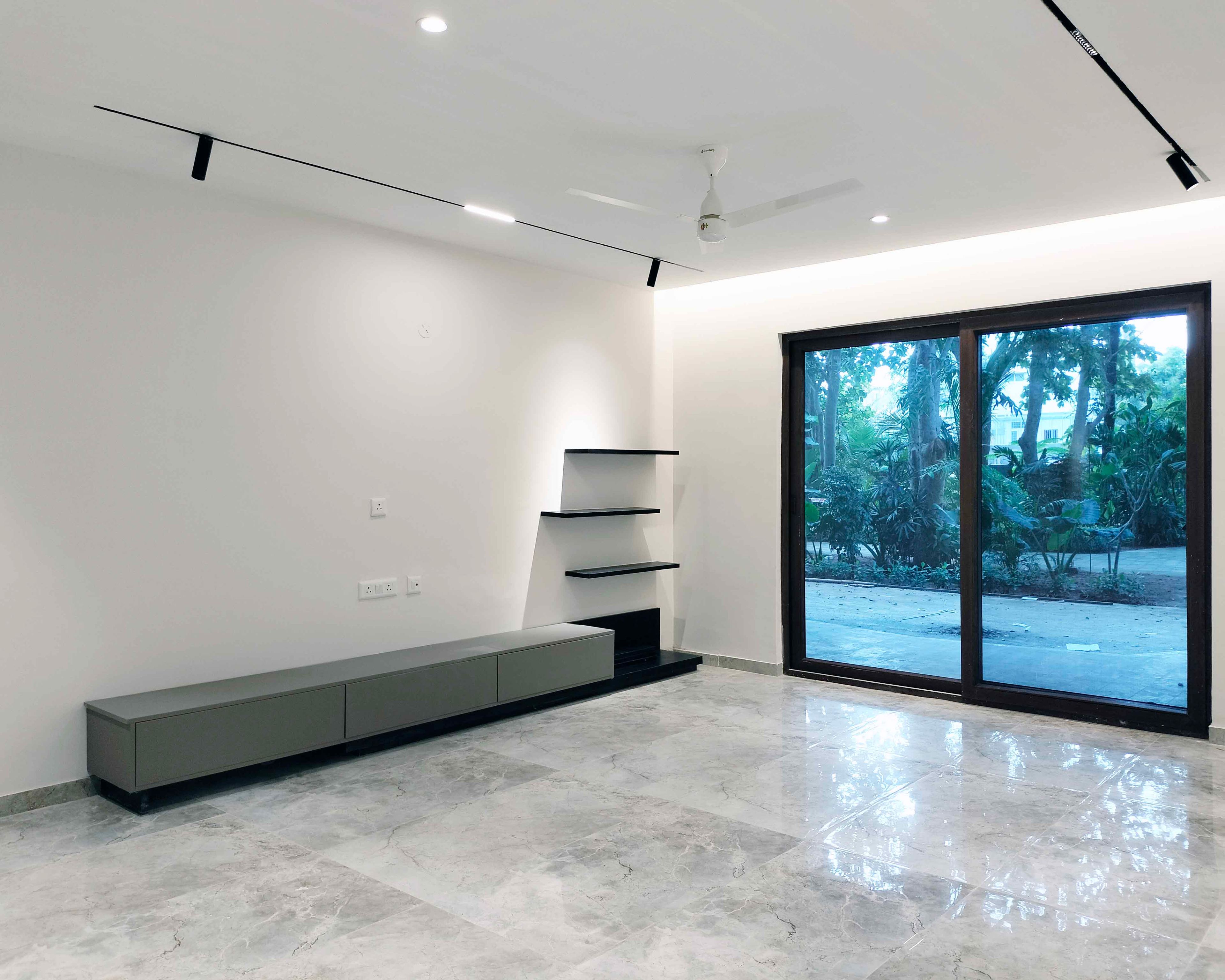 Living Room Design with Spotlights and TV Unit Design with Grey Drawers and Dark Blue Open Shelves