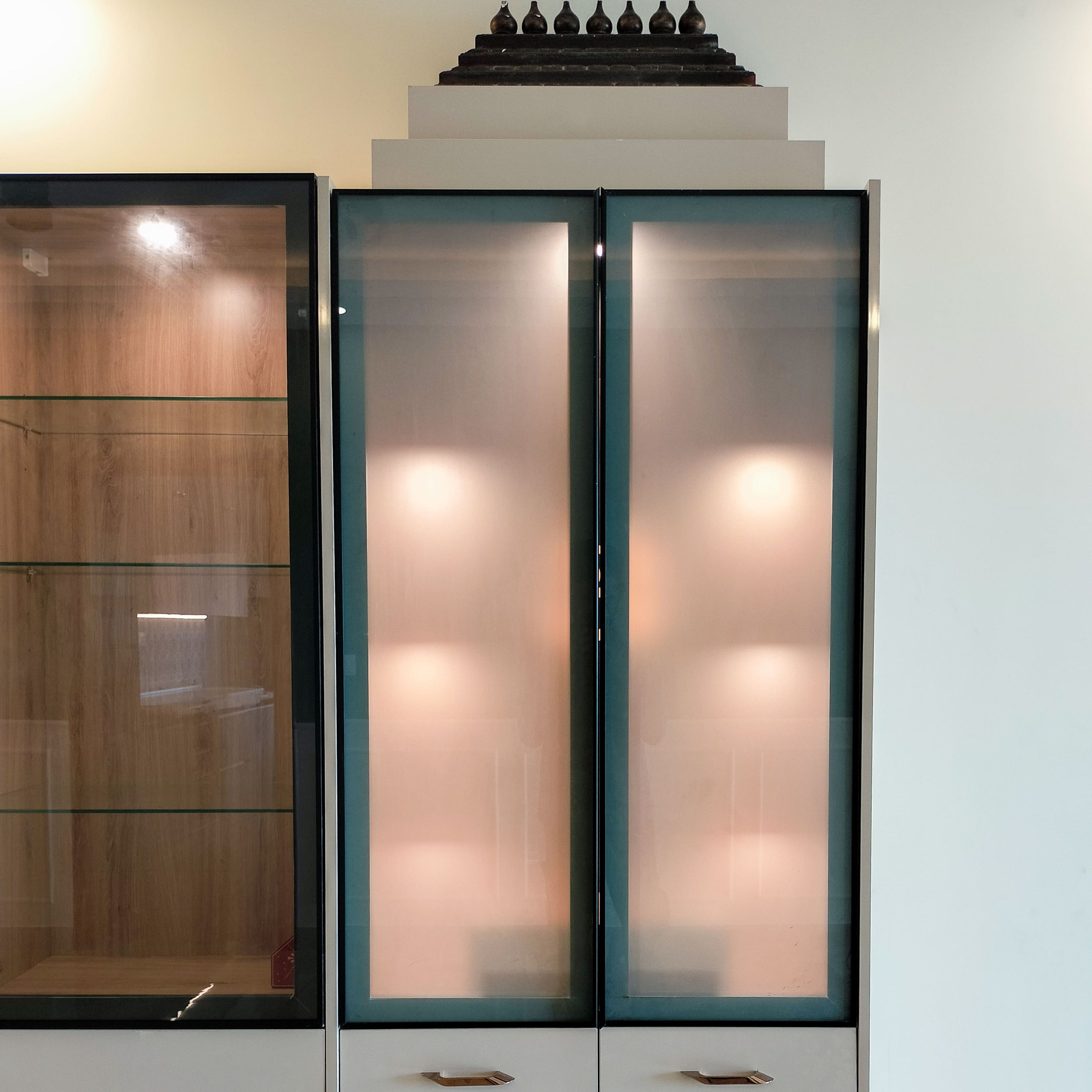 Pooja Unit Design with Glass Shutter Doors and Under Cabinet Lighting