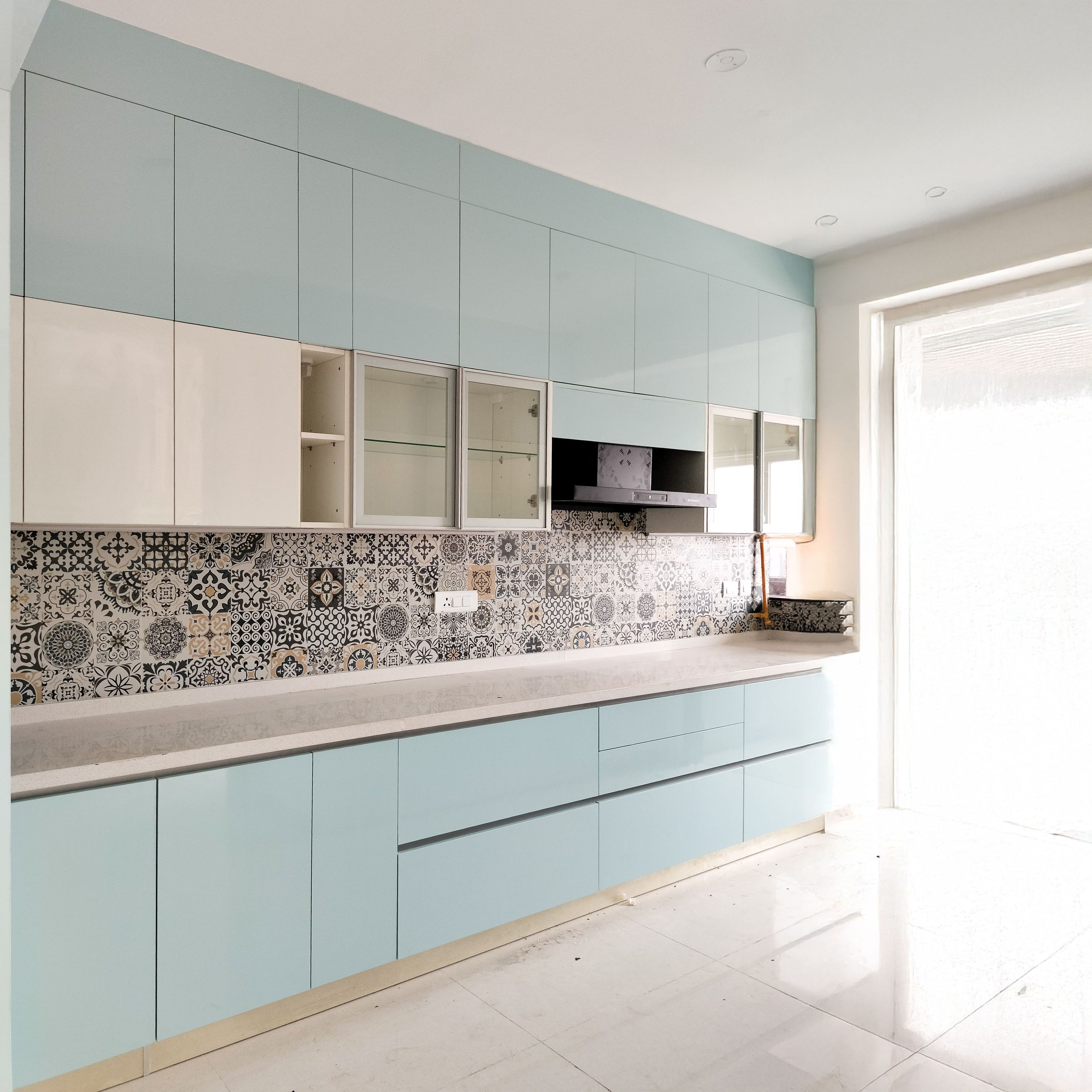 Parallel Kitchen Design with Aqua Blue and White Cabinets and Patterned Tile Backsplash
