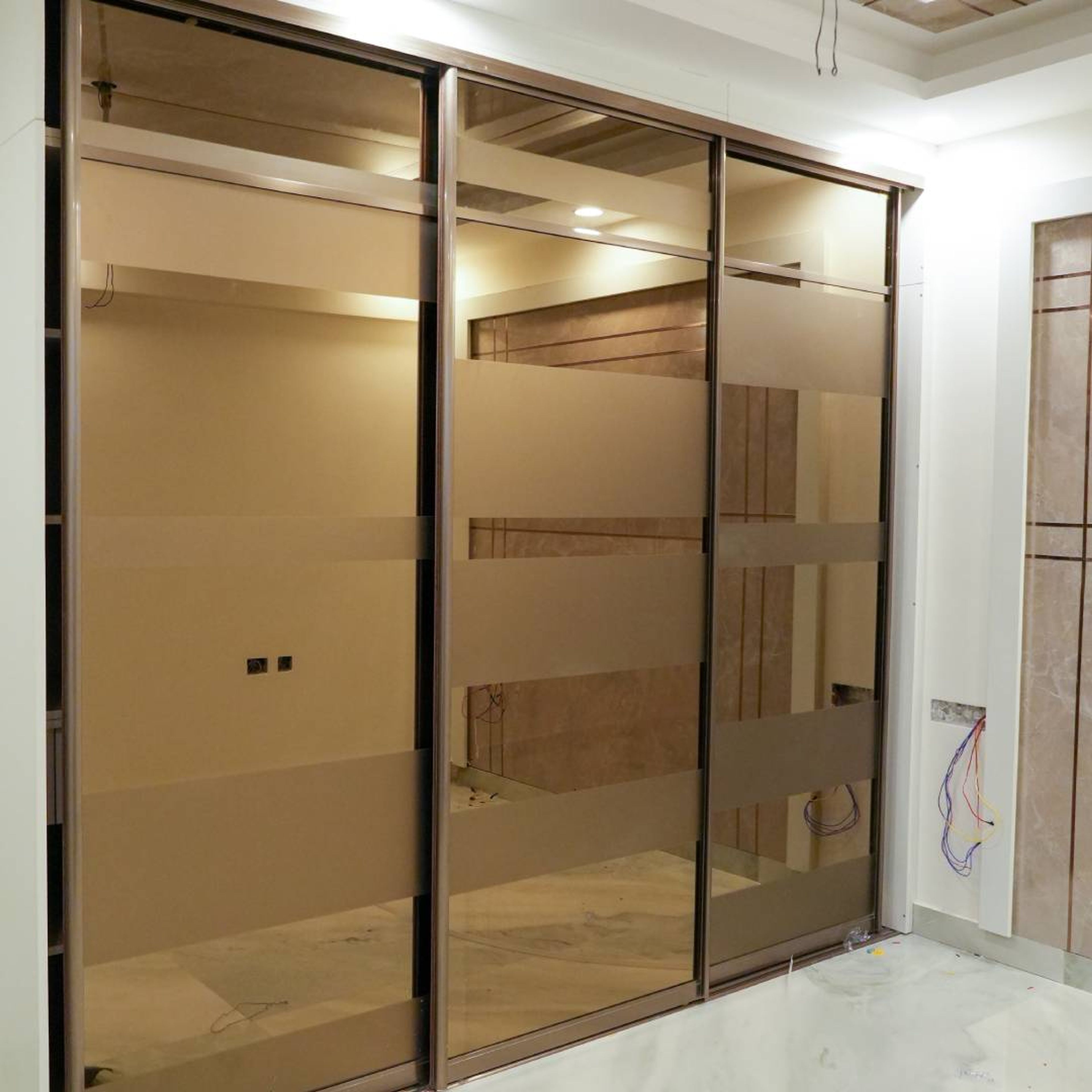 Modern Sliding Wardrobe Design with Brown Tint Glass and Bronze Frame