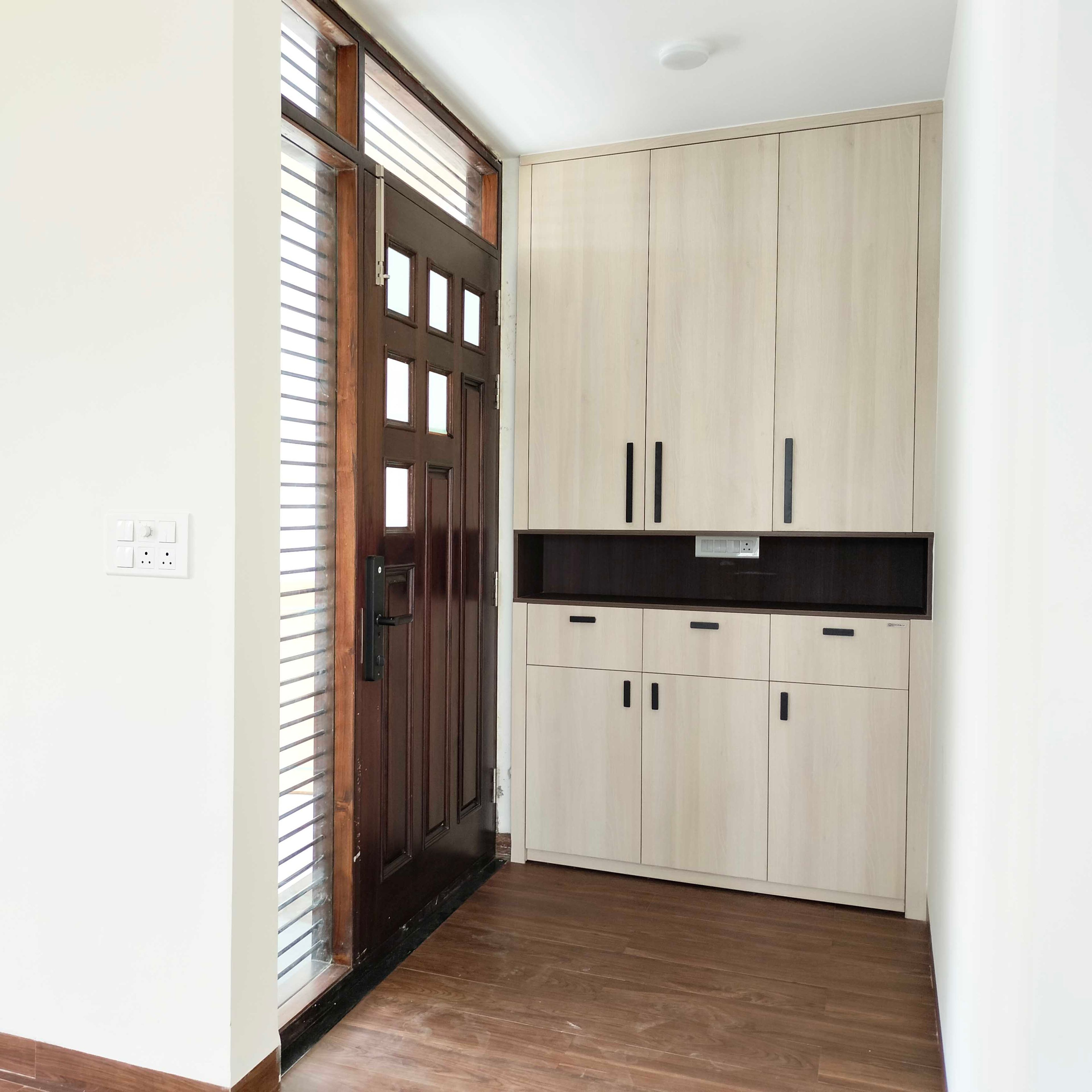 Foyer Design with Wooden Single Door and Cream Floor-to-Ceiling Storage Unit