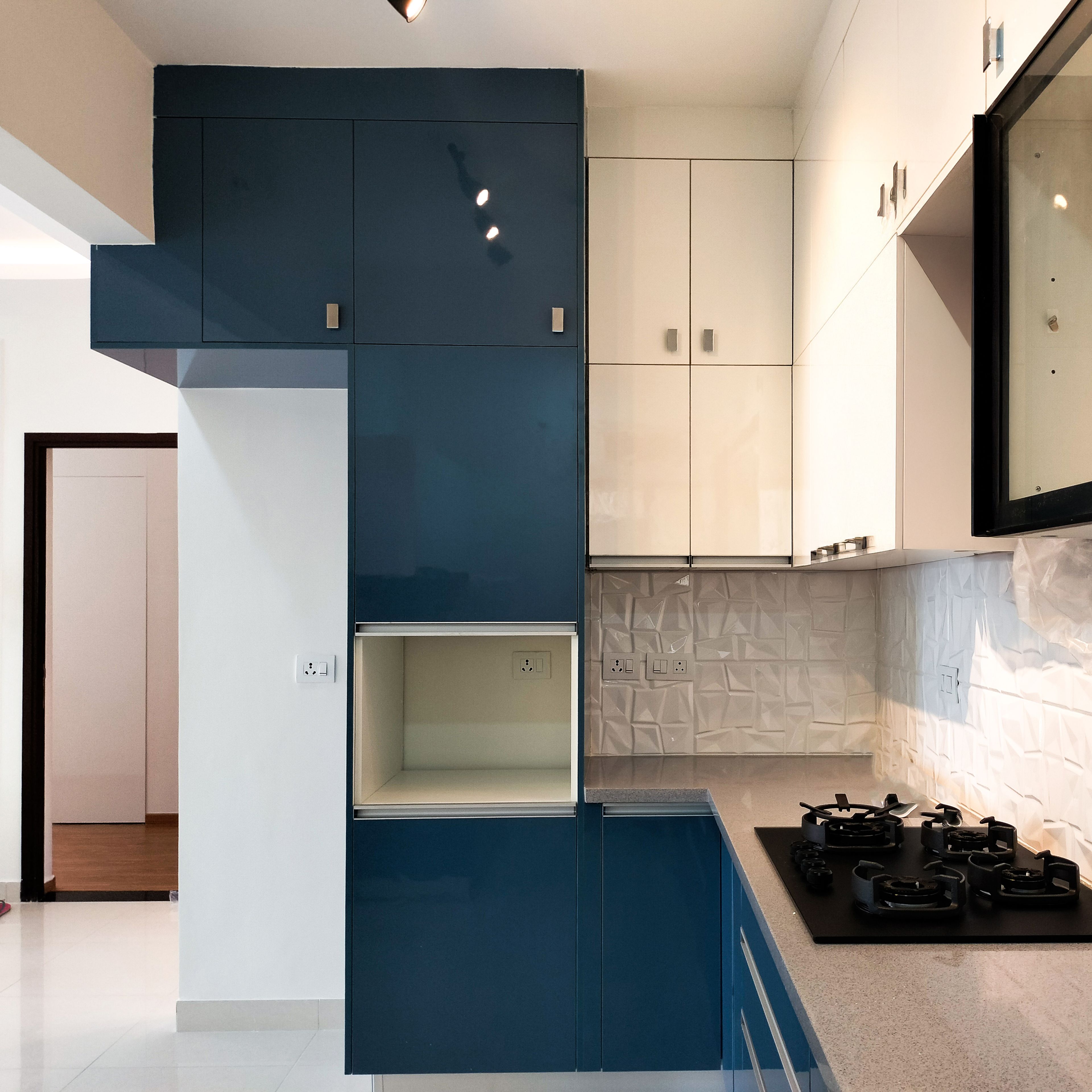 U-Shaped Kitchen Design with Cream and Navy Blue Cabinets and Textured Marble Backsplash