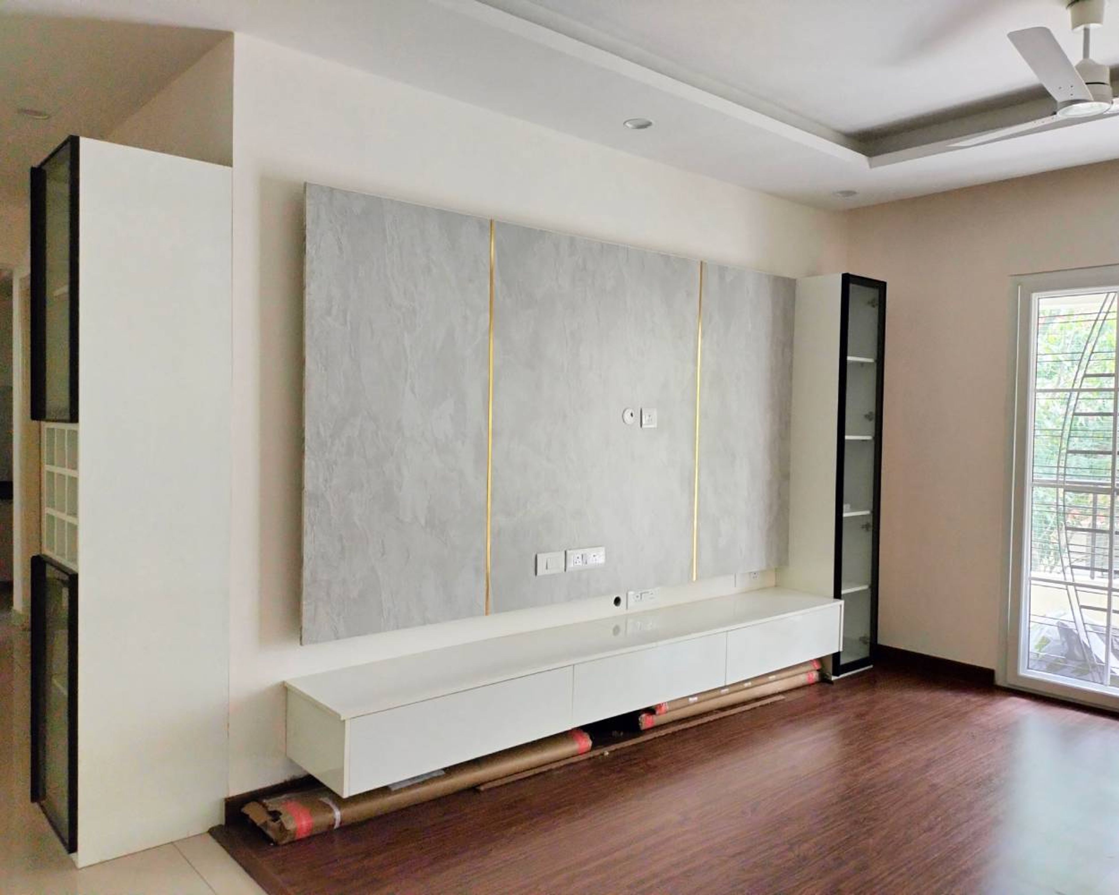 TV Unit Design with Grey Textured Wall with Gold Inlays and Floating Drawers