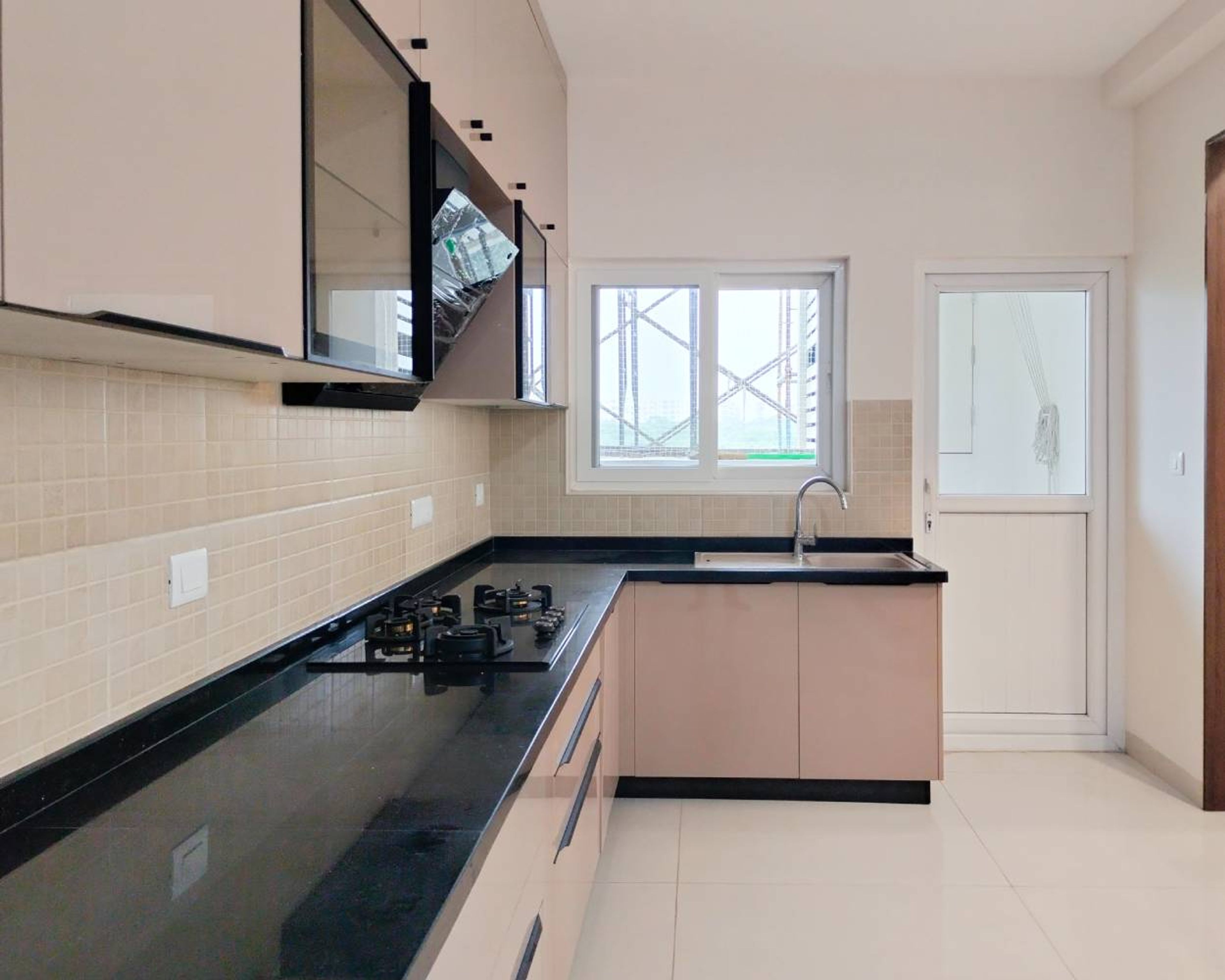 L-Shaped Kitchen Design with Peach Cabinets and Black Granite Countertop