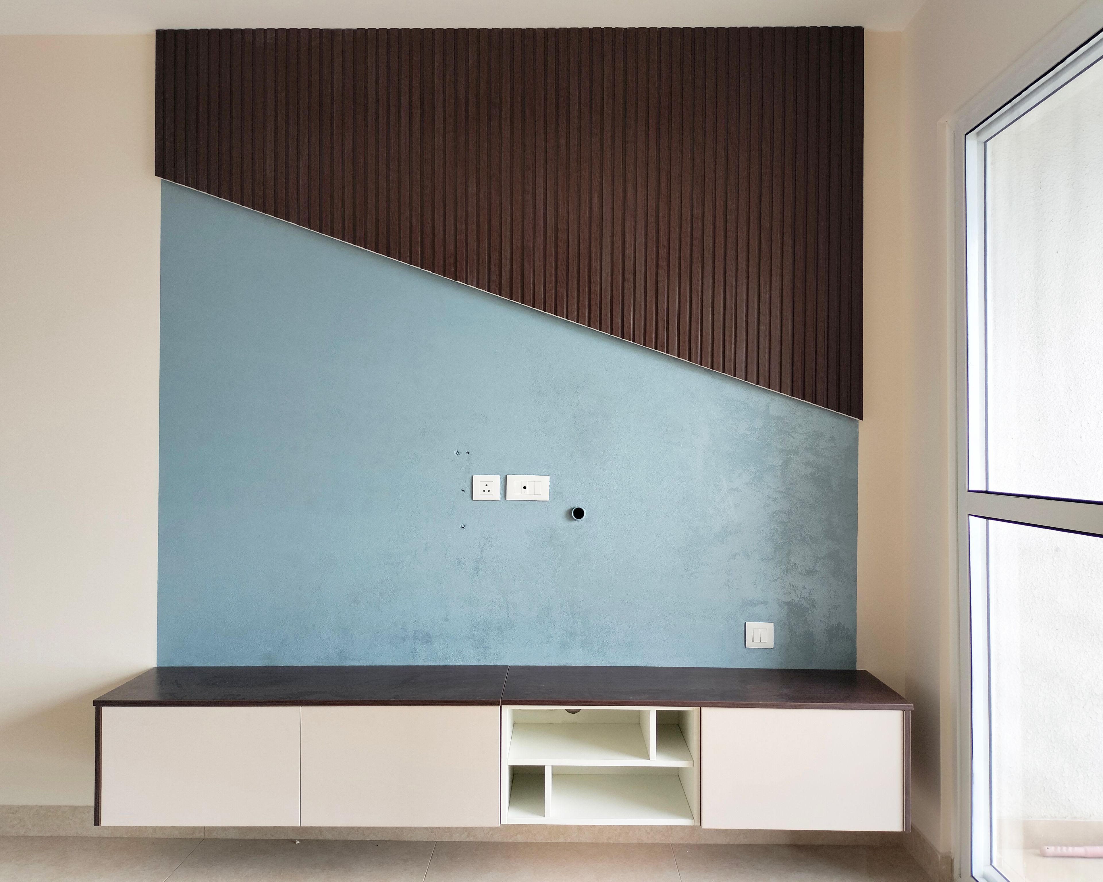 TV Unit Design with Blue Wall and Geometric Brown Wall Grooves