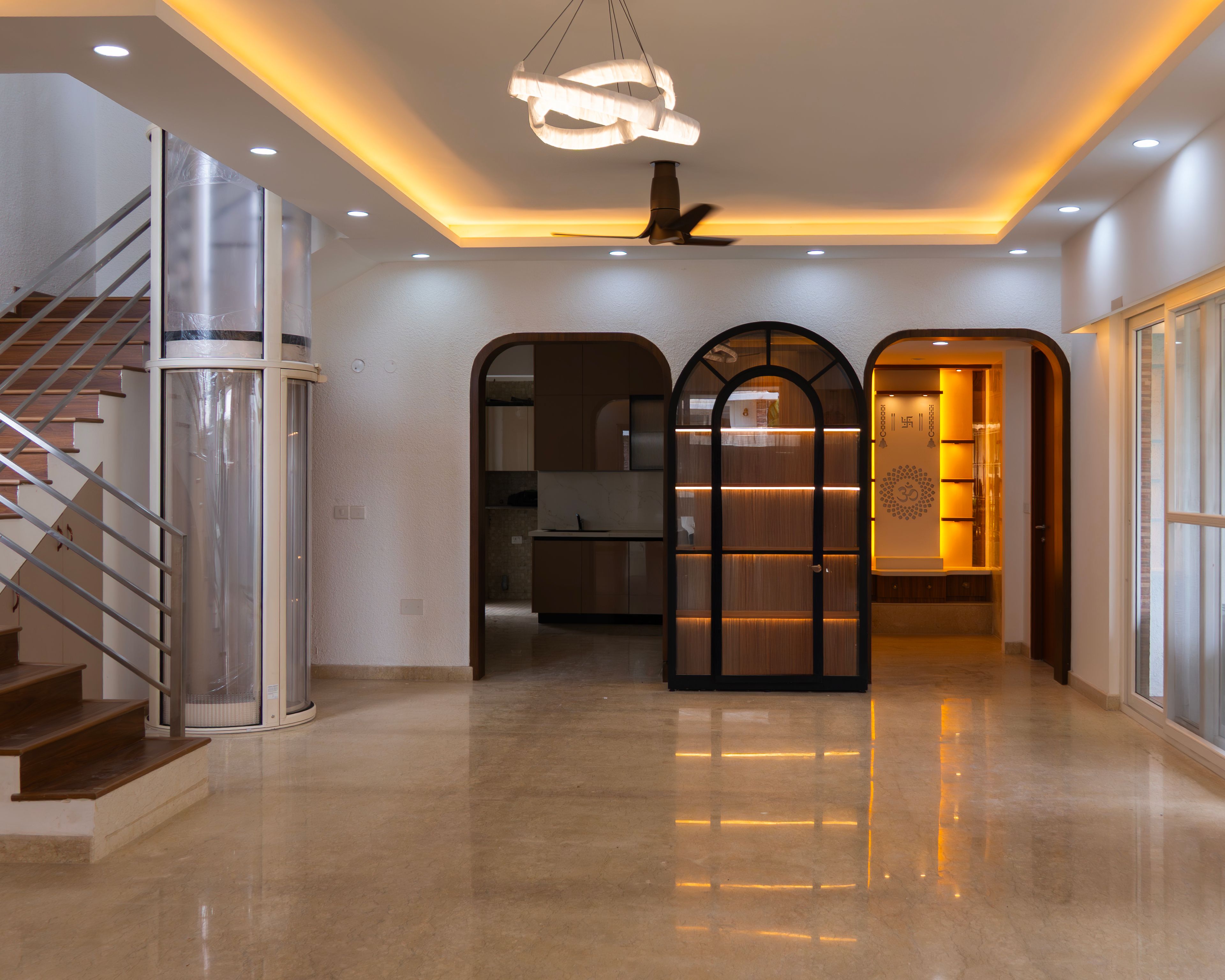 Living Room Design with Staircase, Arched Crockery Unit, and Glass Elevator