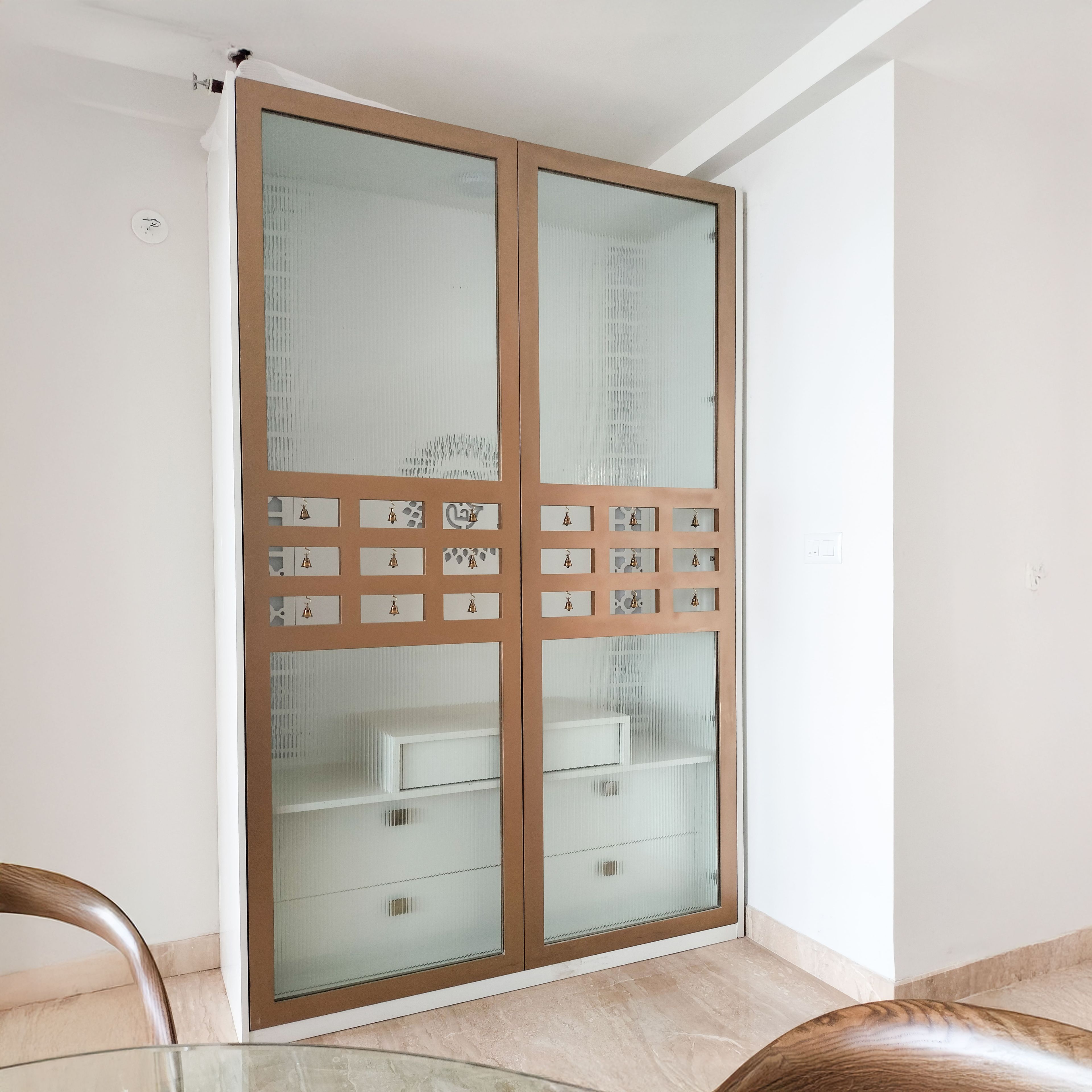 Closed Pooja Unit Design with Frosted Glass Door with Bells