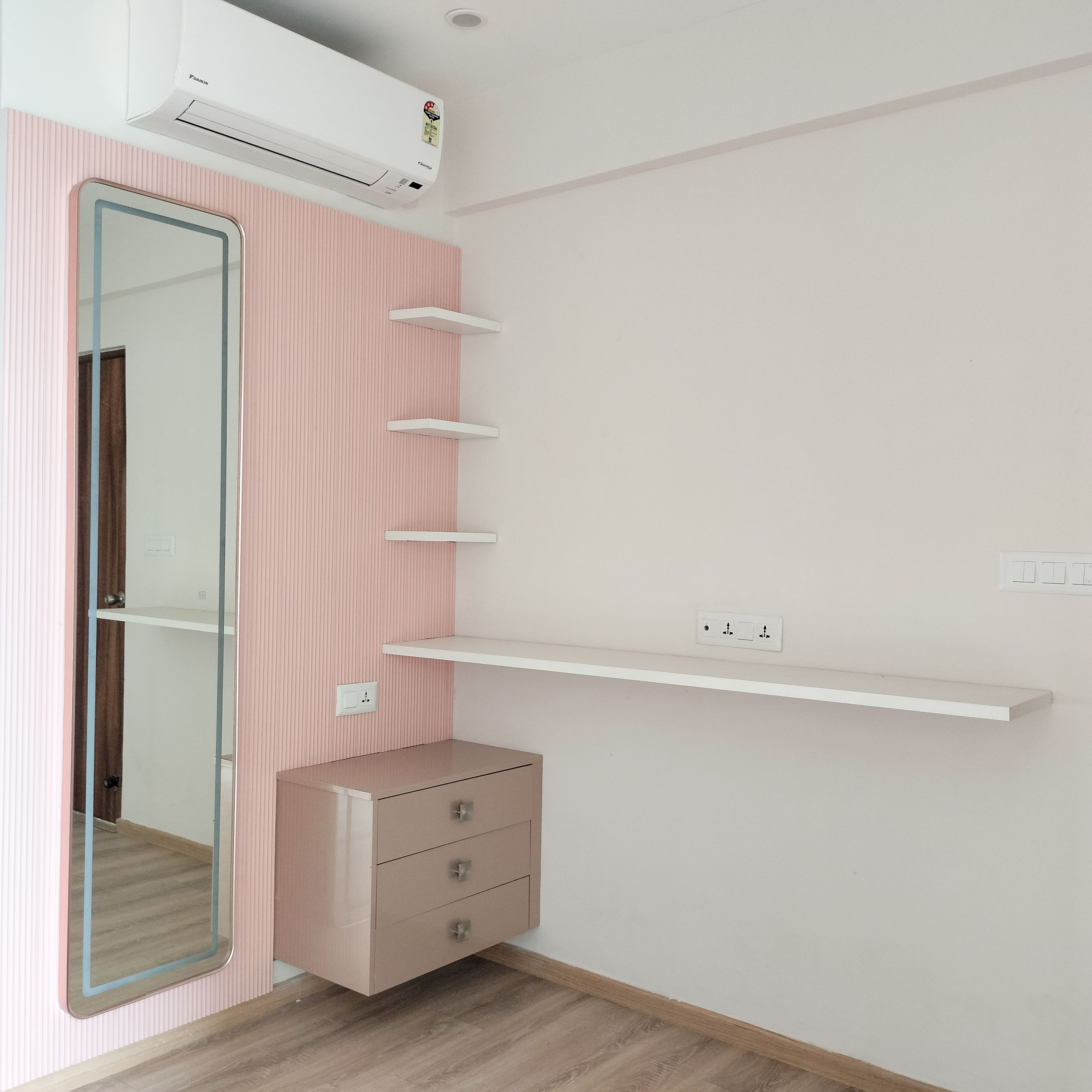 Vertical Pink Wall Slats with White Wall Mounted Shelves with Rectangular Mirror and Light Brown Cabinets