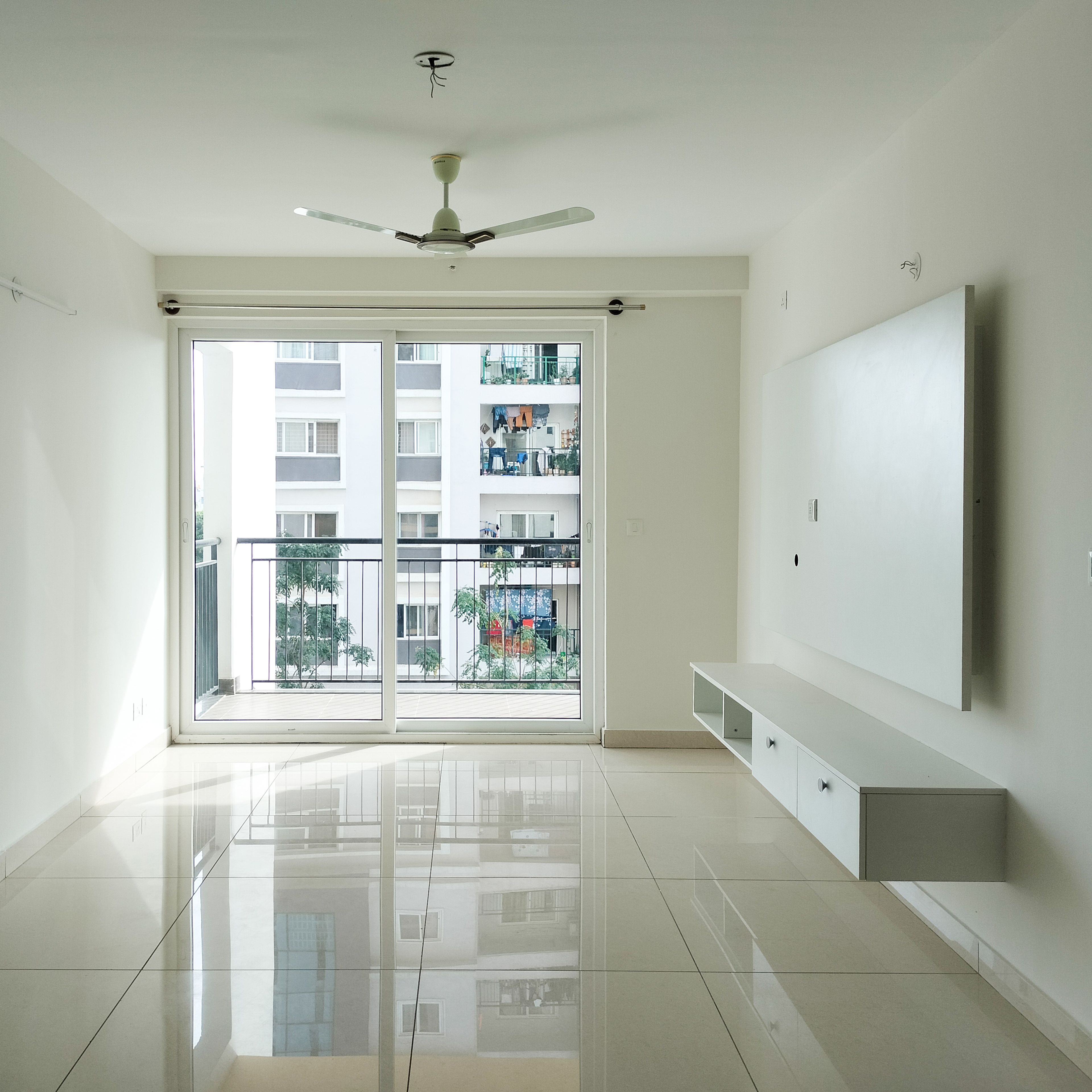 Living Room Design with White TV Unit and Sliding Glass Balcony Door