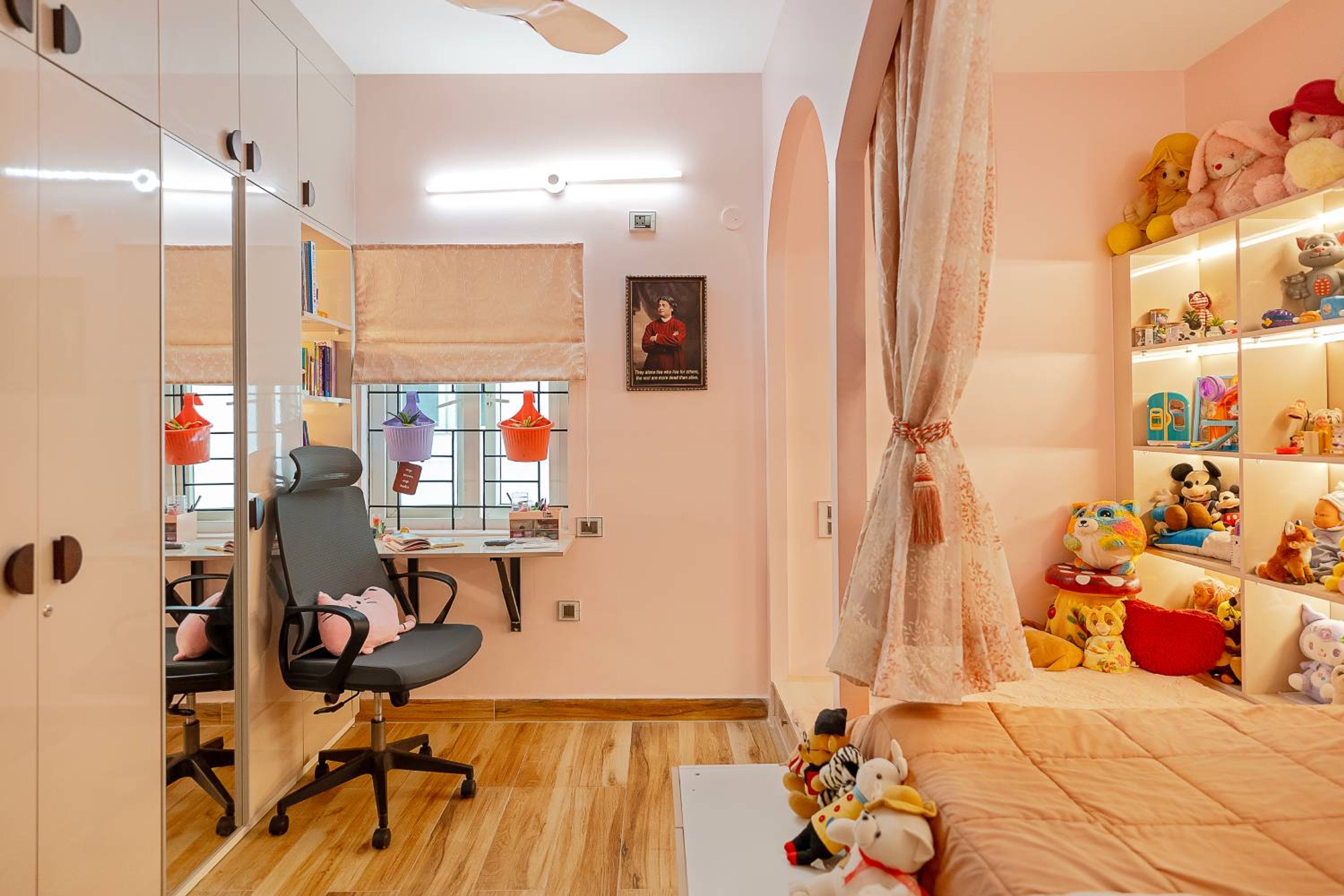 Kids bedroom with soft pink walls, built-in toy shelves, plush toys, and cozy curtains