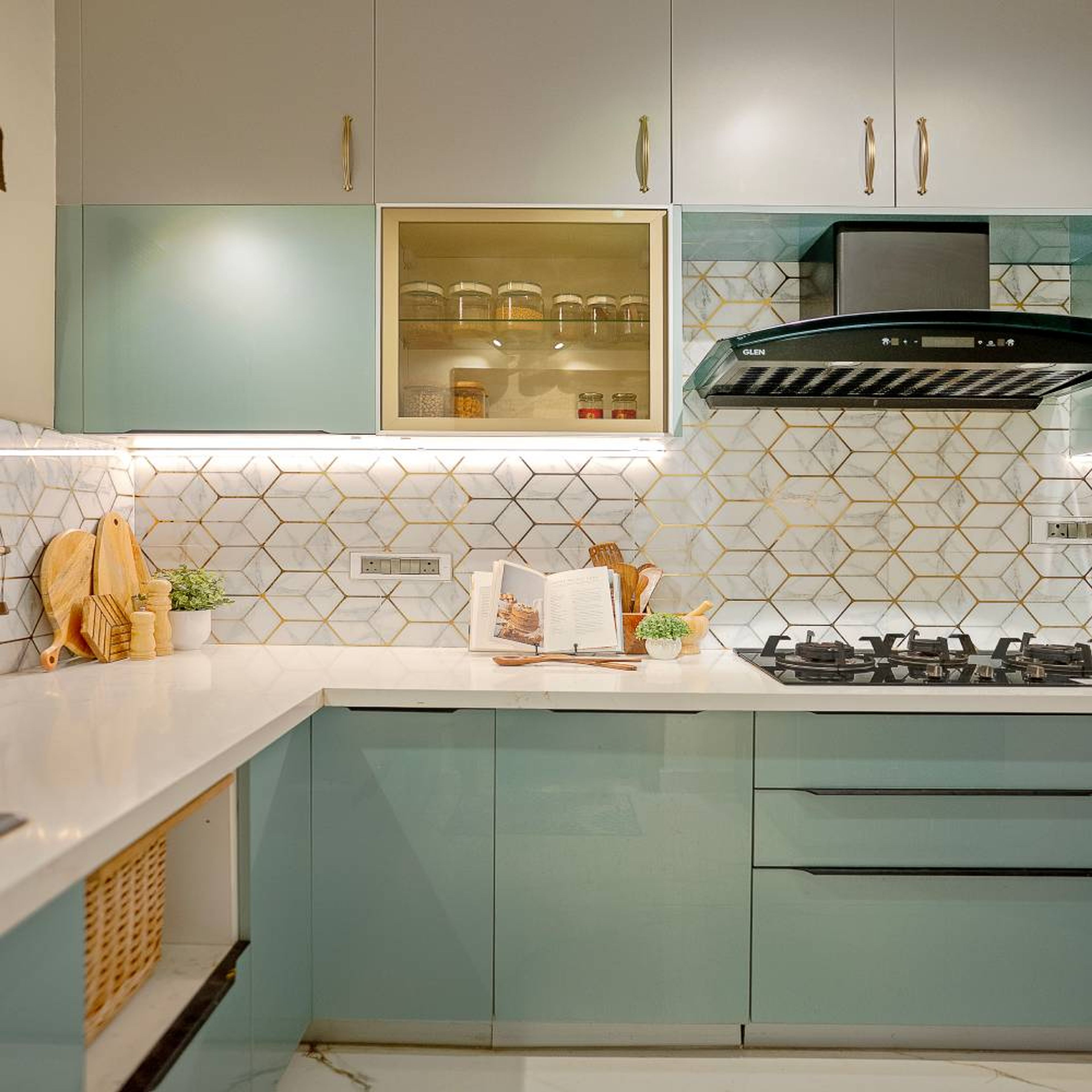 Pastel green and white L-Shaped kitchen with geometric backsplash, wicker basket drawer, and LED lighting