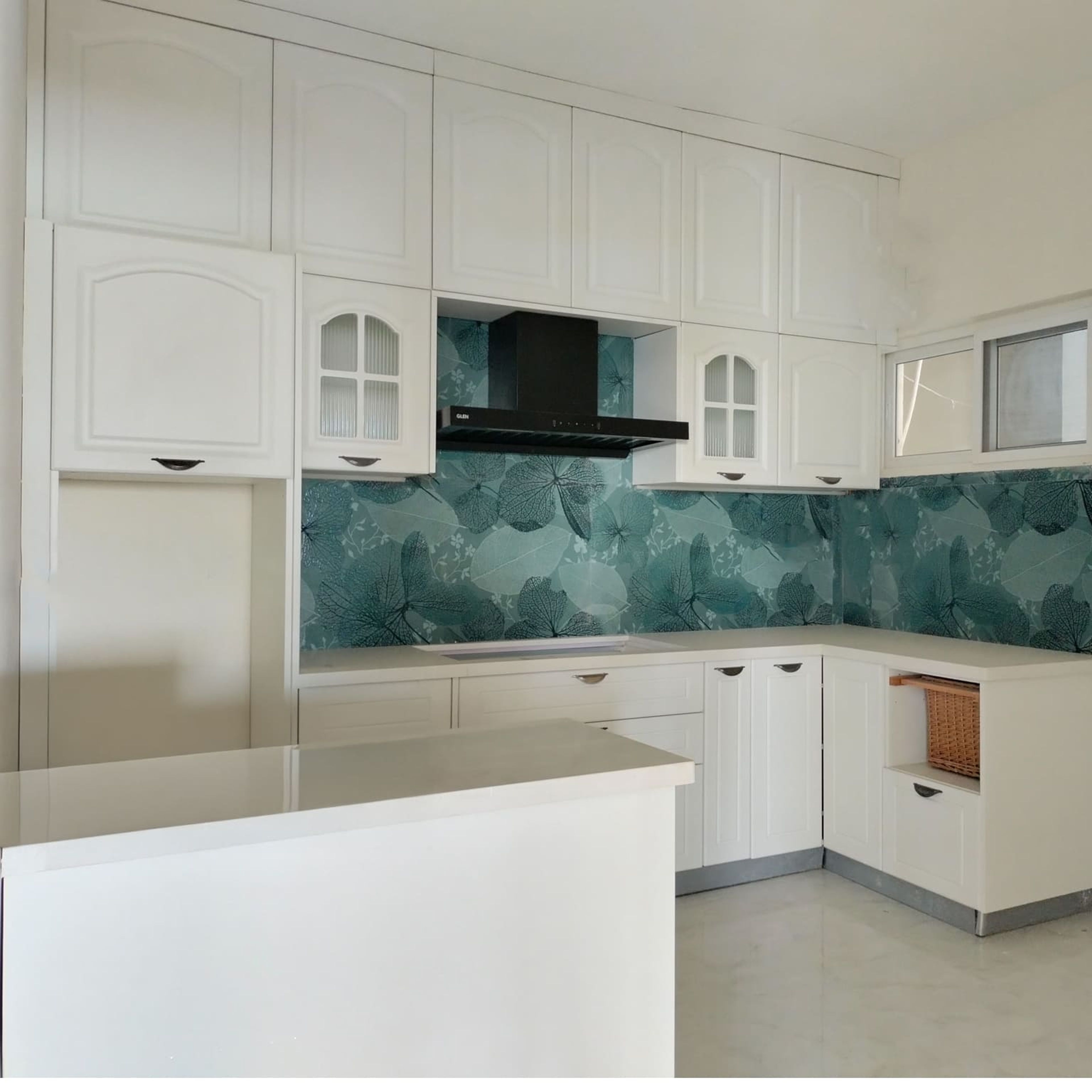 L-Shaped Kitchen Design with White Units and Floral Patterned Teal Backsplash