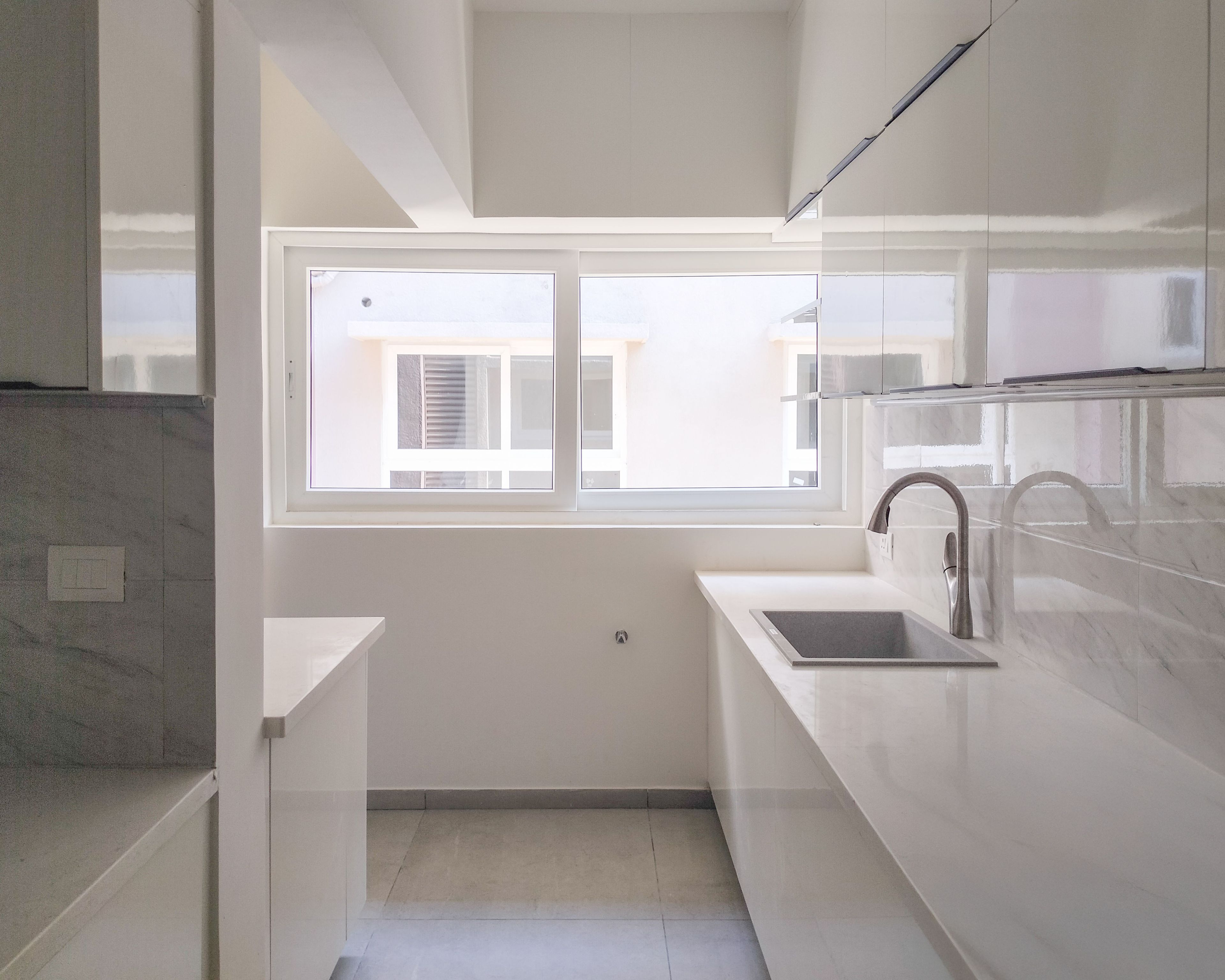 L-Shaped Kitchen Design with White Quartz Countertop and White Units