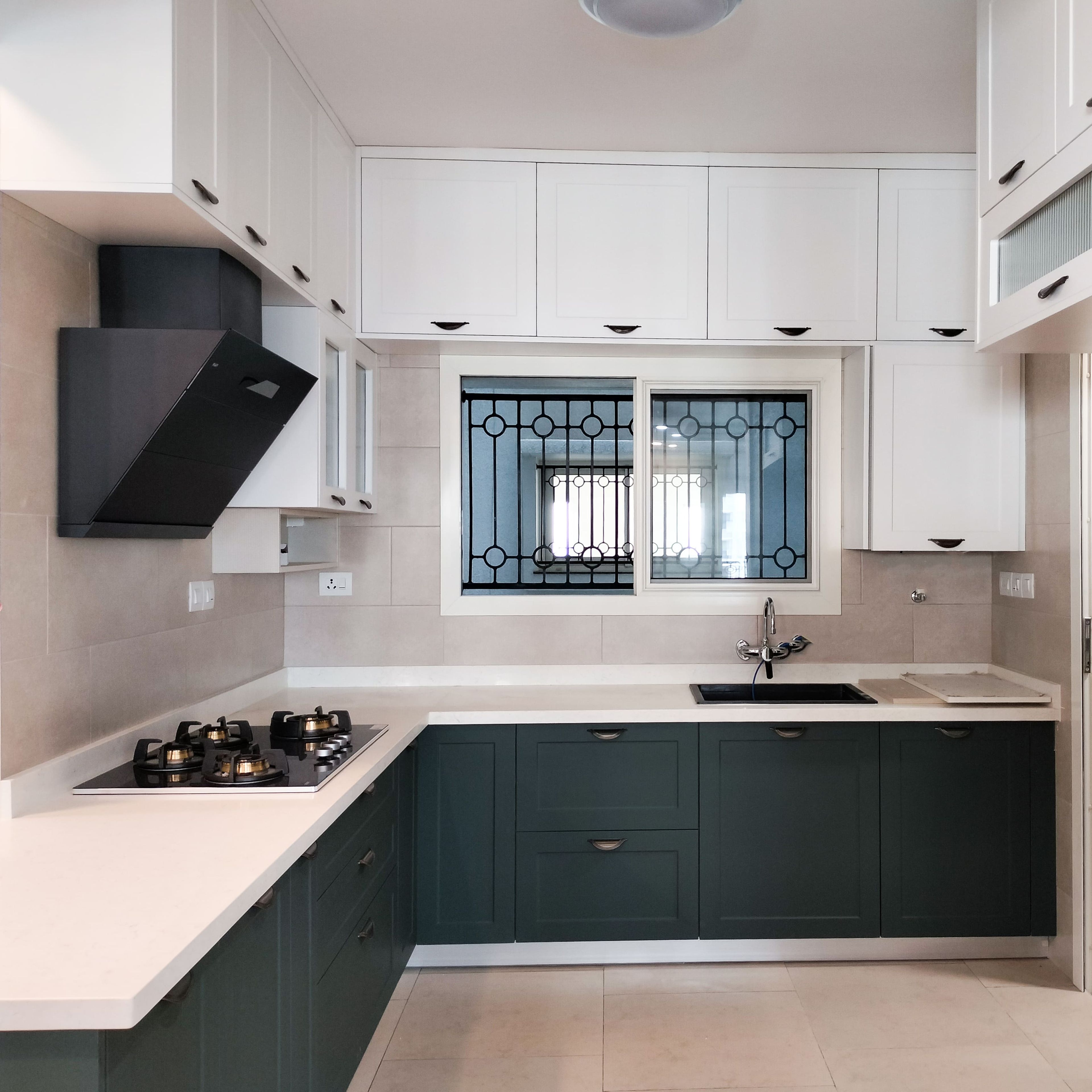 L-shaped kitchen design with green base units