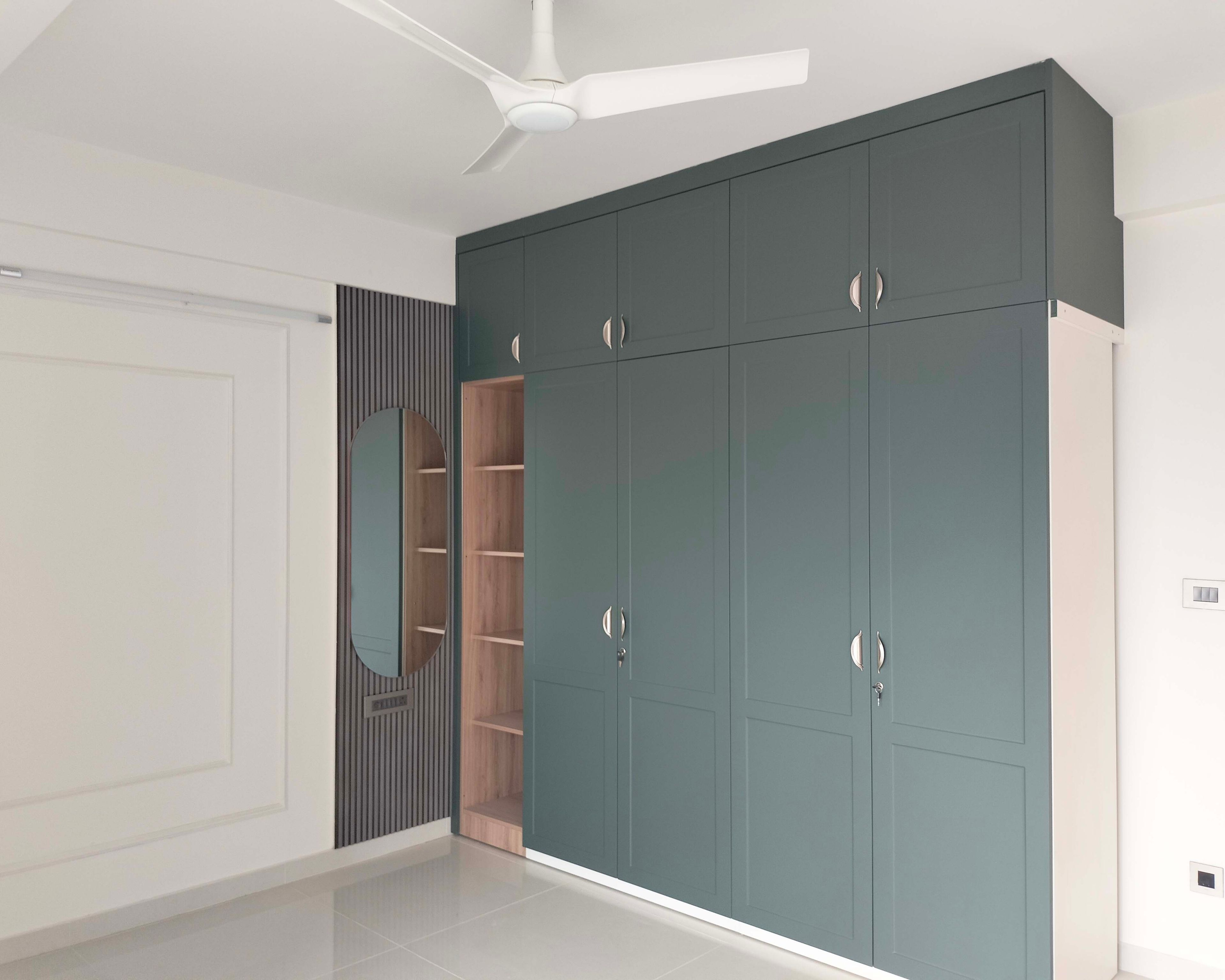 4-Door Greyish Green Swing Wardrobe Design with Open Tall Unit and Wall Mounted Mirror on Slatted Wall