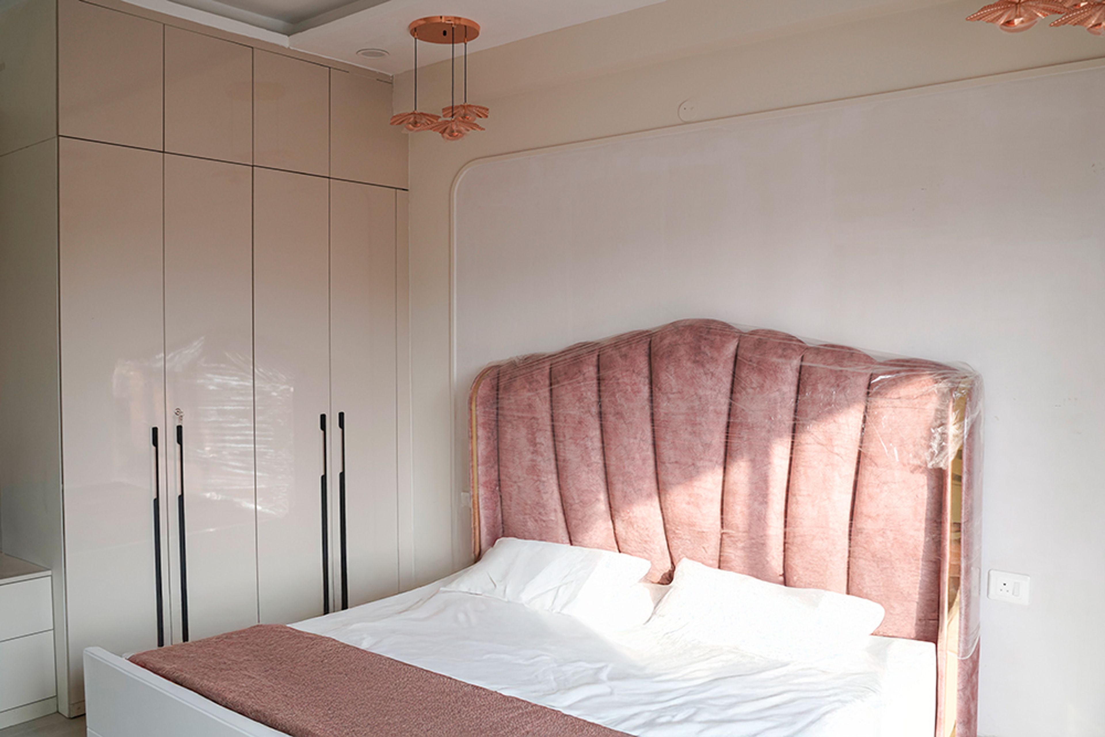 Bedroom Design with Pink Floral Cut Cushioned Headboard Bed and 4-Door Cream Swing Wardrobe