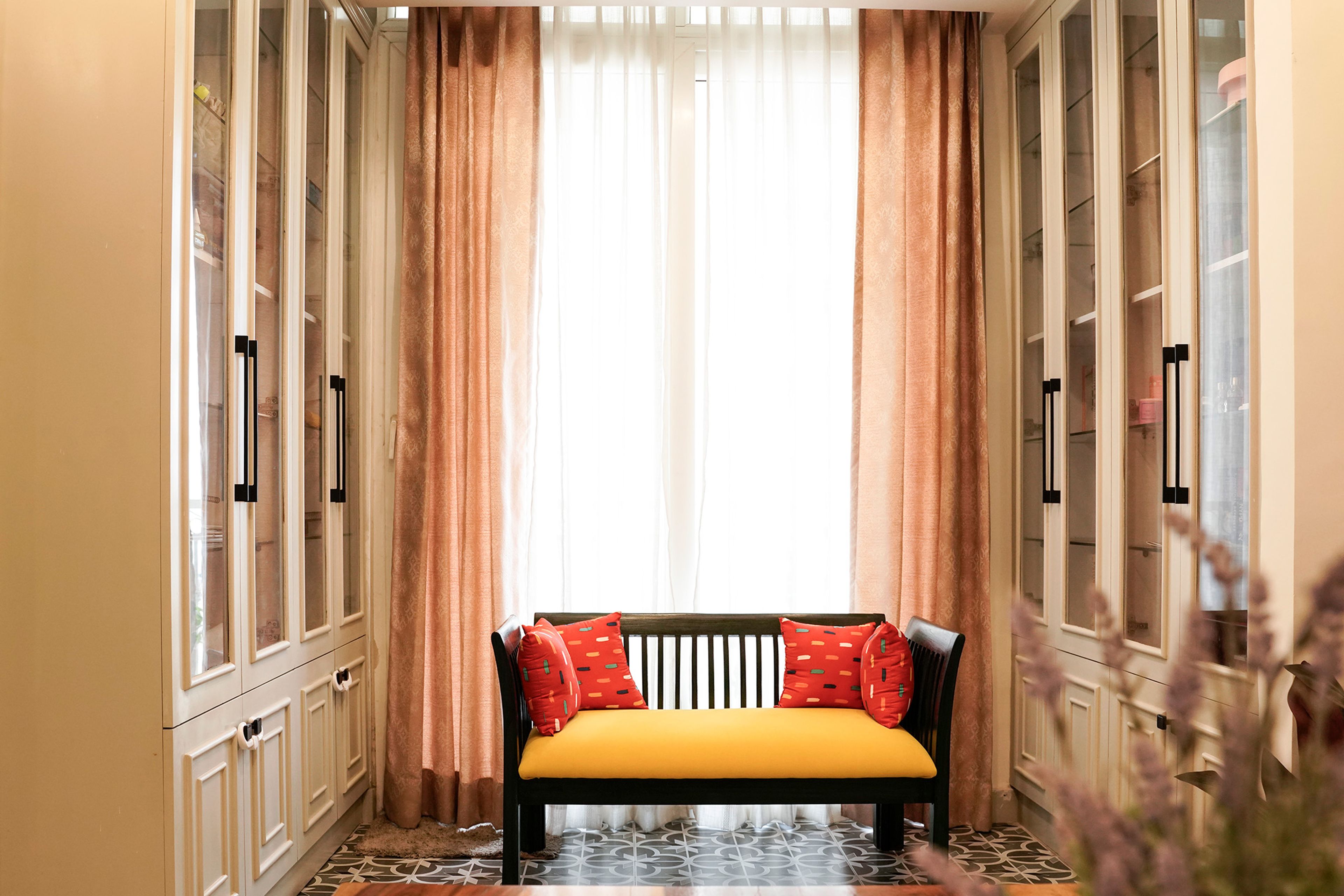 Seating Space with Yellow Cushioned Bench with Bookshelf on Both Sides