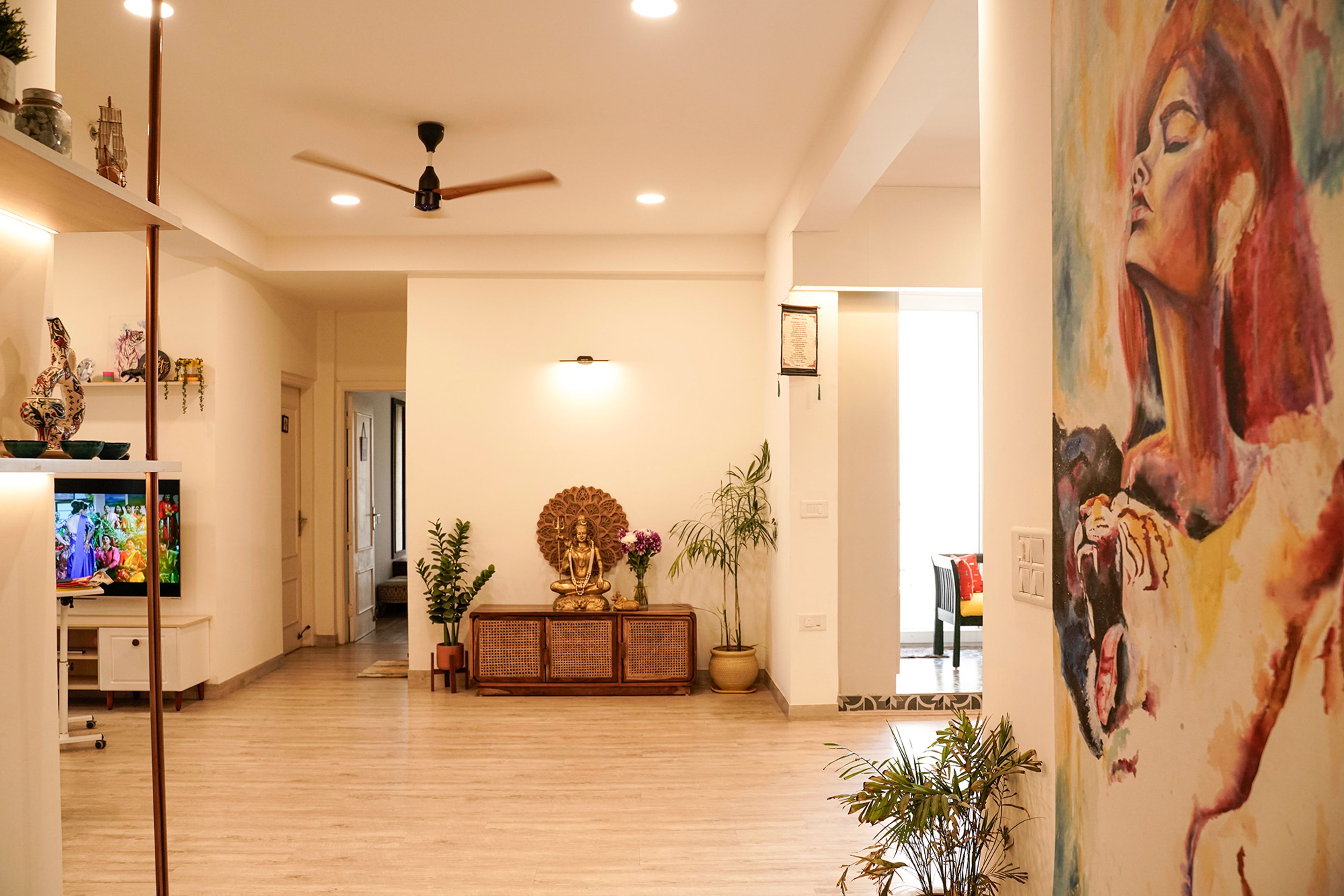 Living Room Design with Large Artistic Wall Mural, Minimalist Media Cabinet, and Indoor Greenery