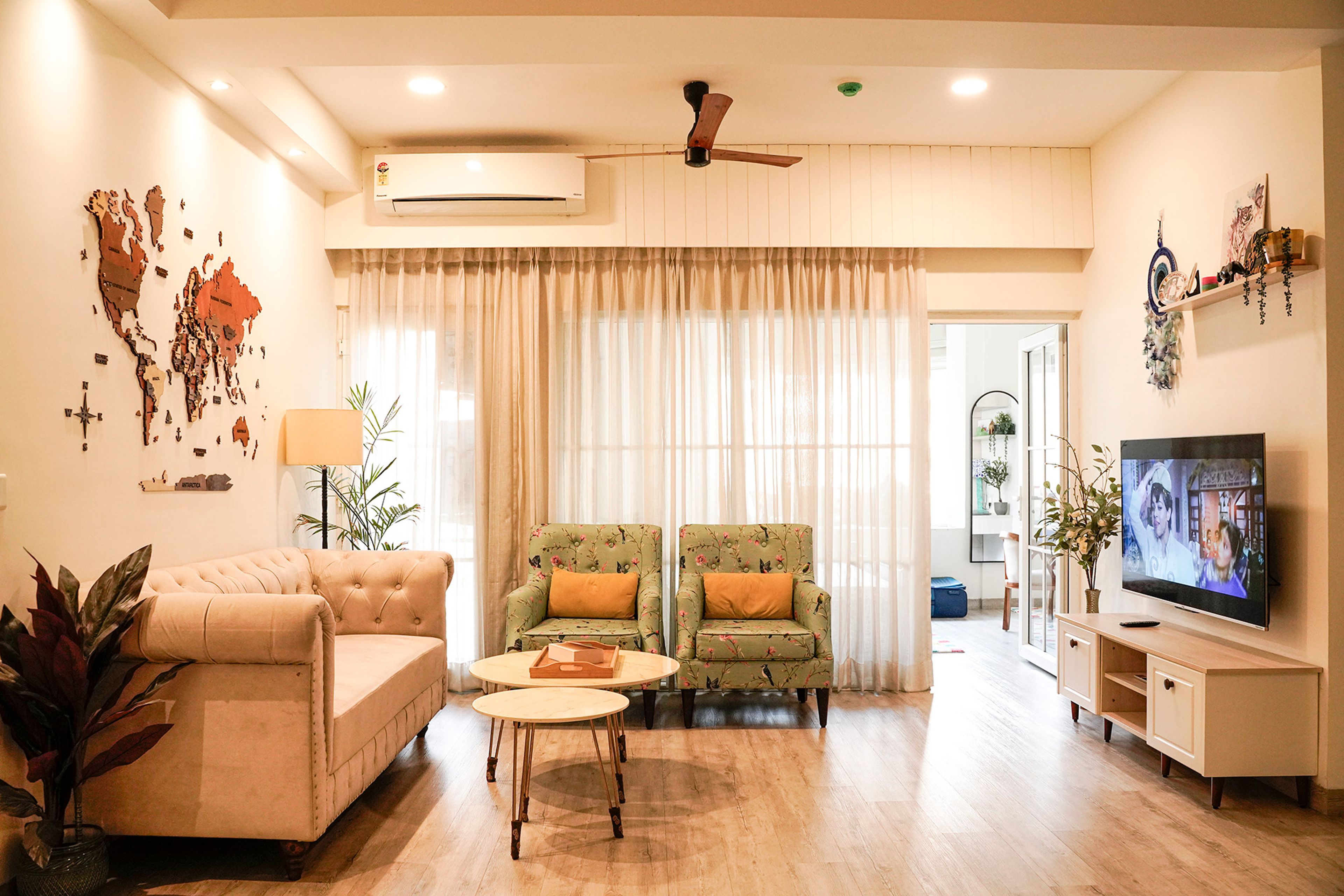 Living Room Design with Peach Sofa, Two Single Seater Green Floral Sofas, TV Unit and World Map Wall