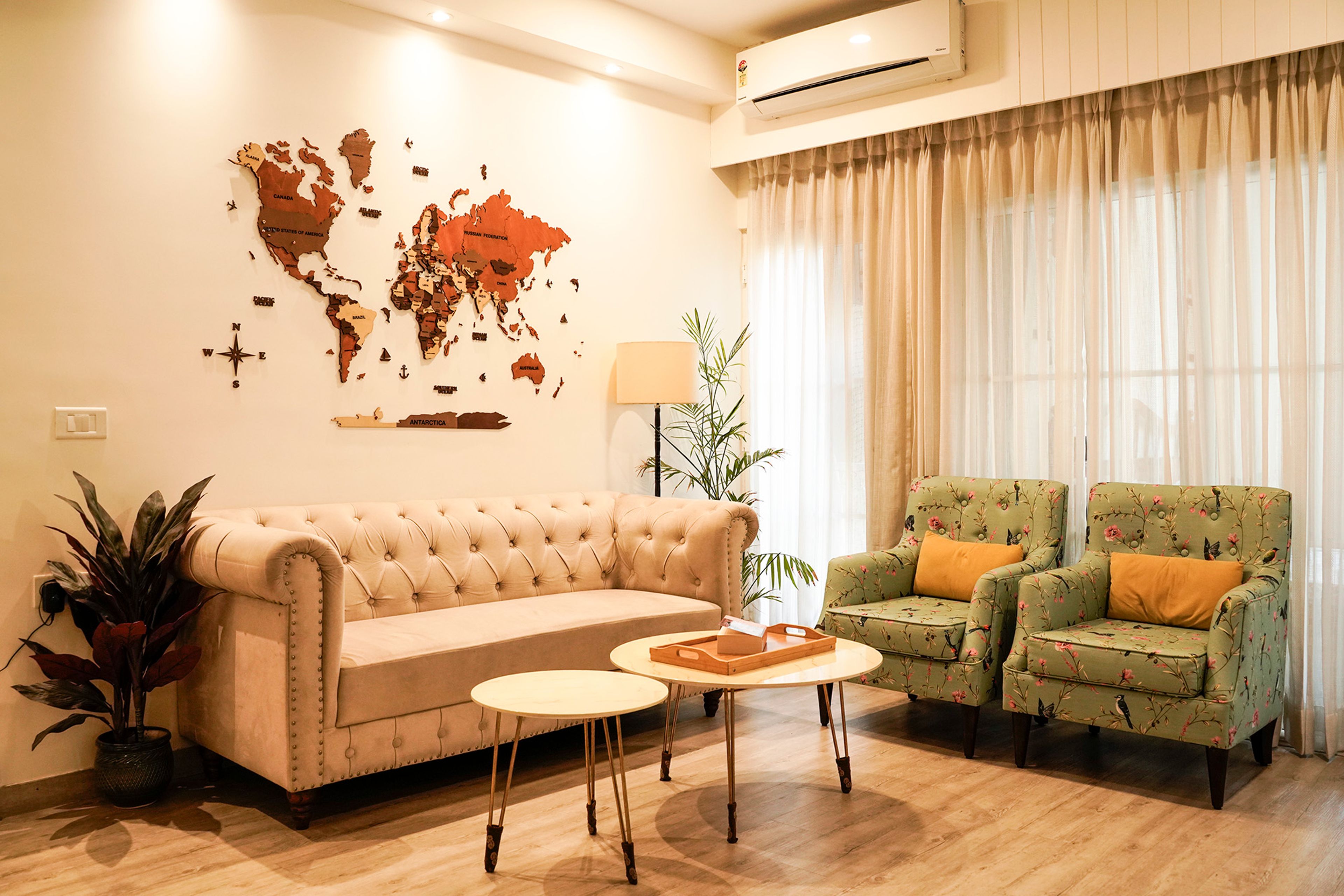 Living Room Design with Peach Sofa, Two Single Seater Green Floral Sofas and World Map Wall