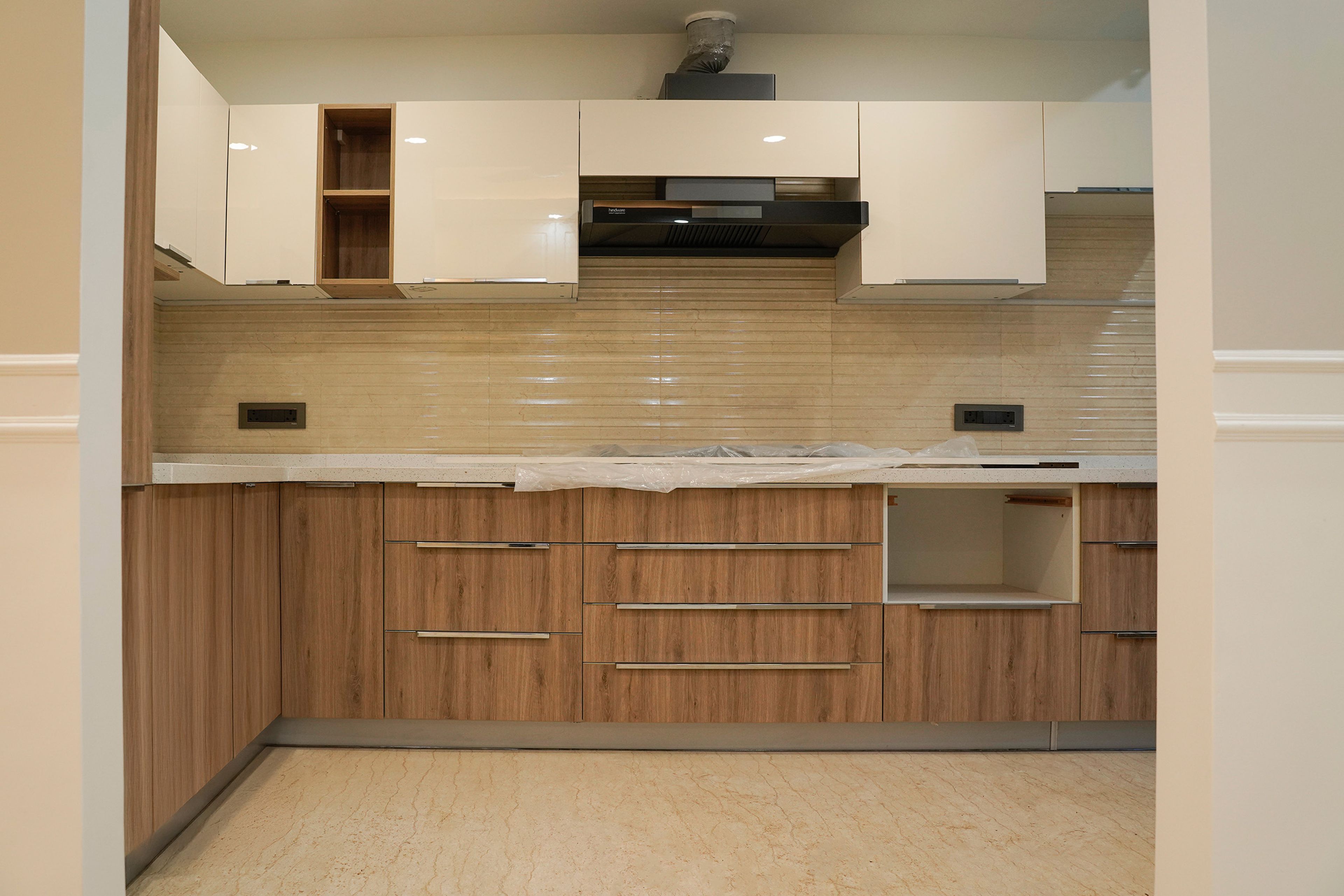 L-shaped kitchen design with beige wall units