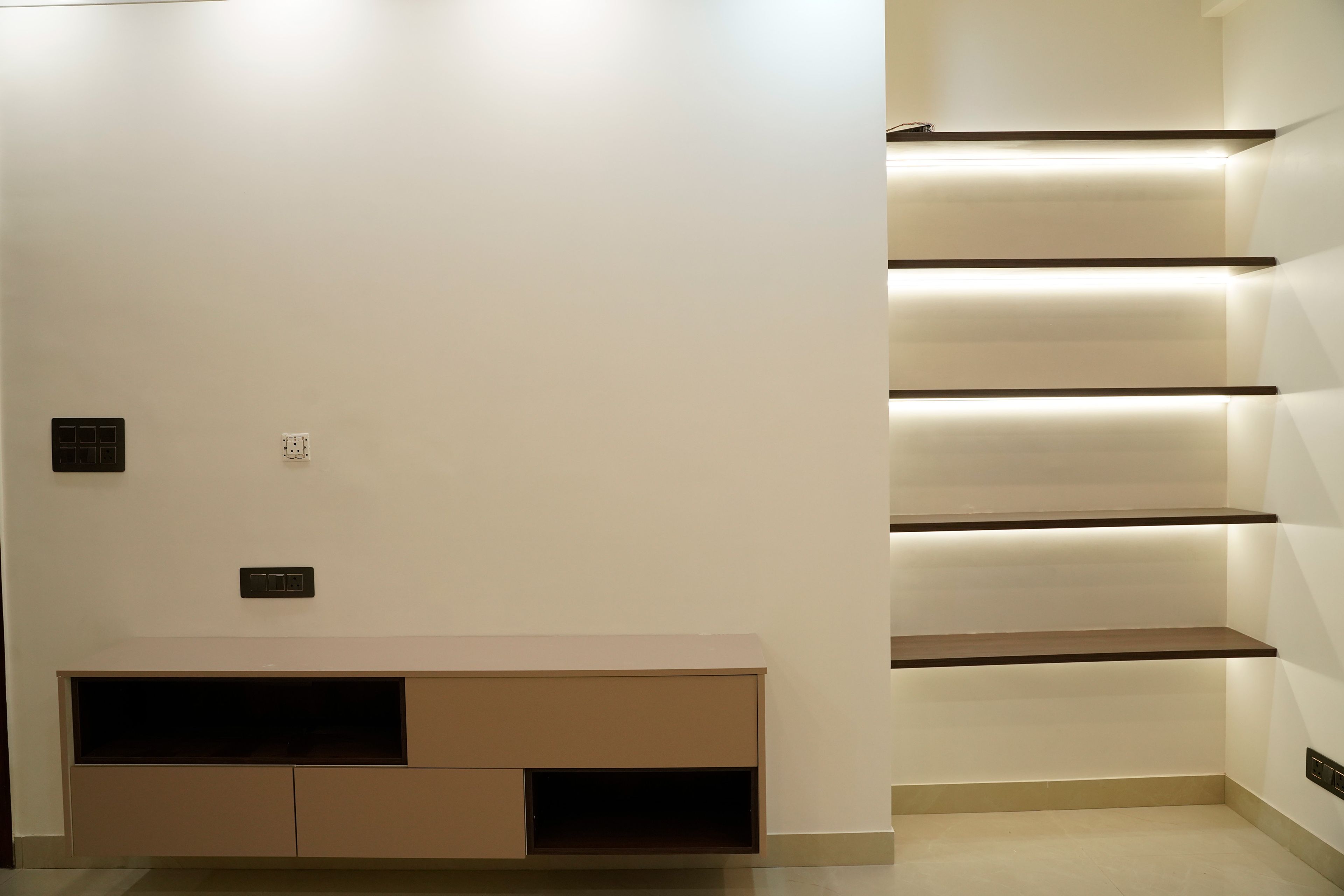 TV unit design with brown drawers and cove lit shelves