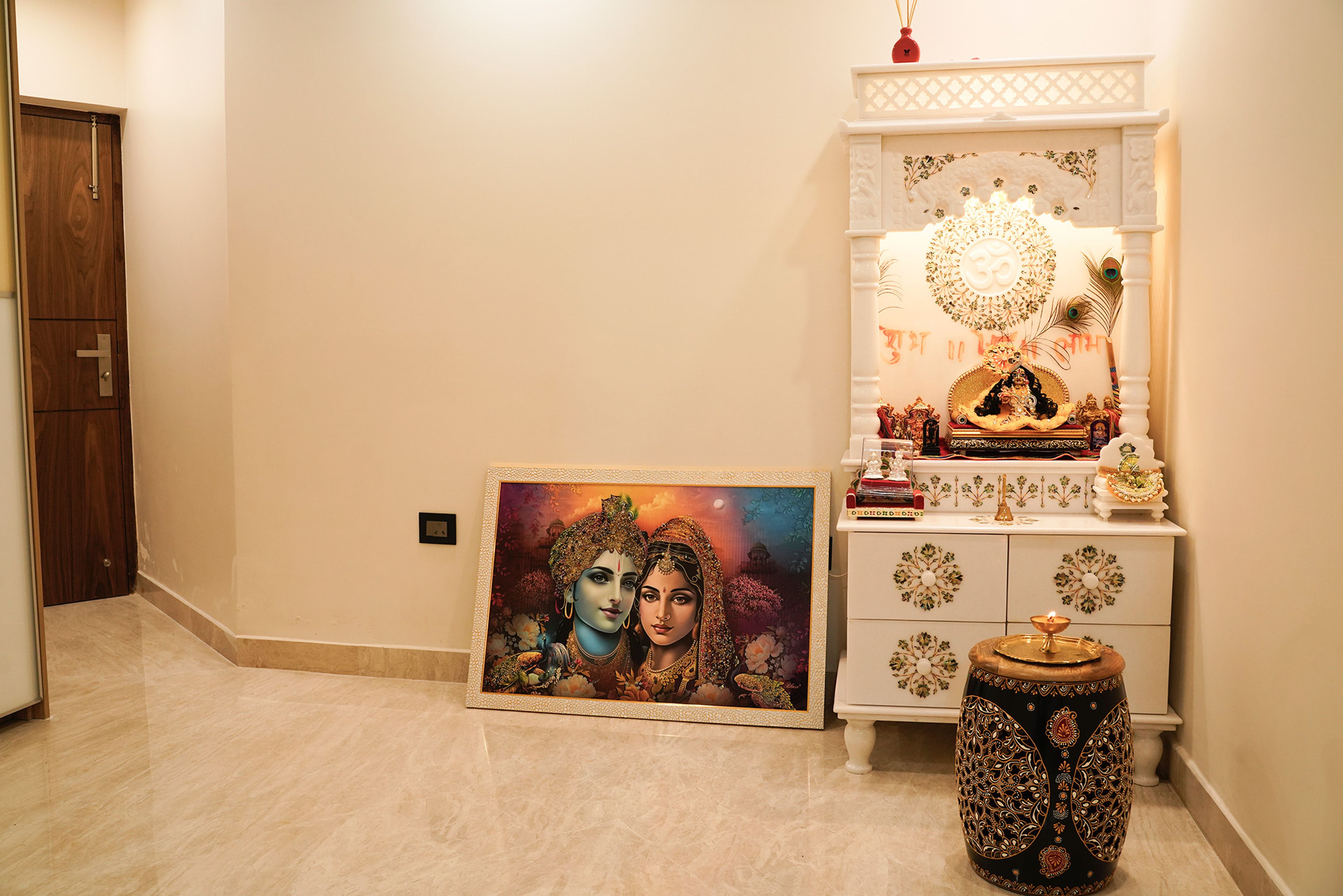 White Pooja Unit Design with OM Engraving and In-Built Drawers