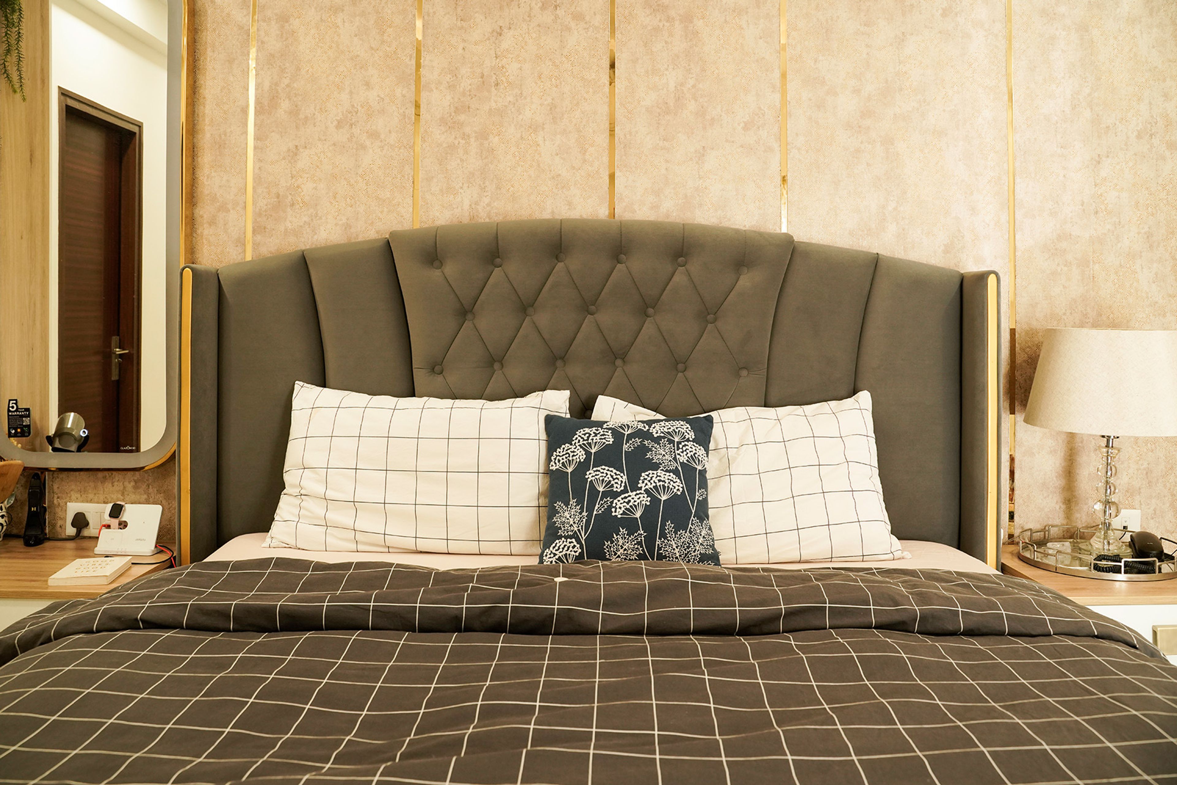 Bedroom Design with Grey Tufted Headboard Bed and Beige Textured Wall with Gold Trims
