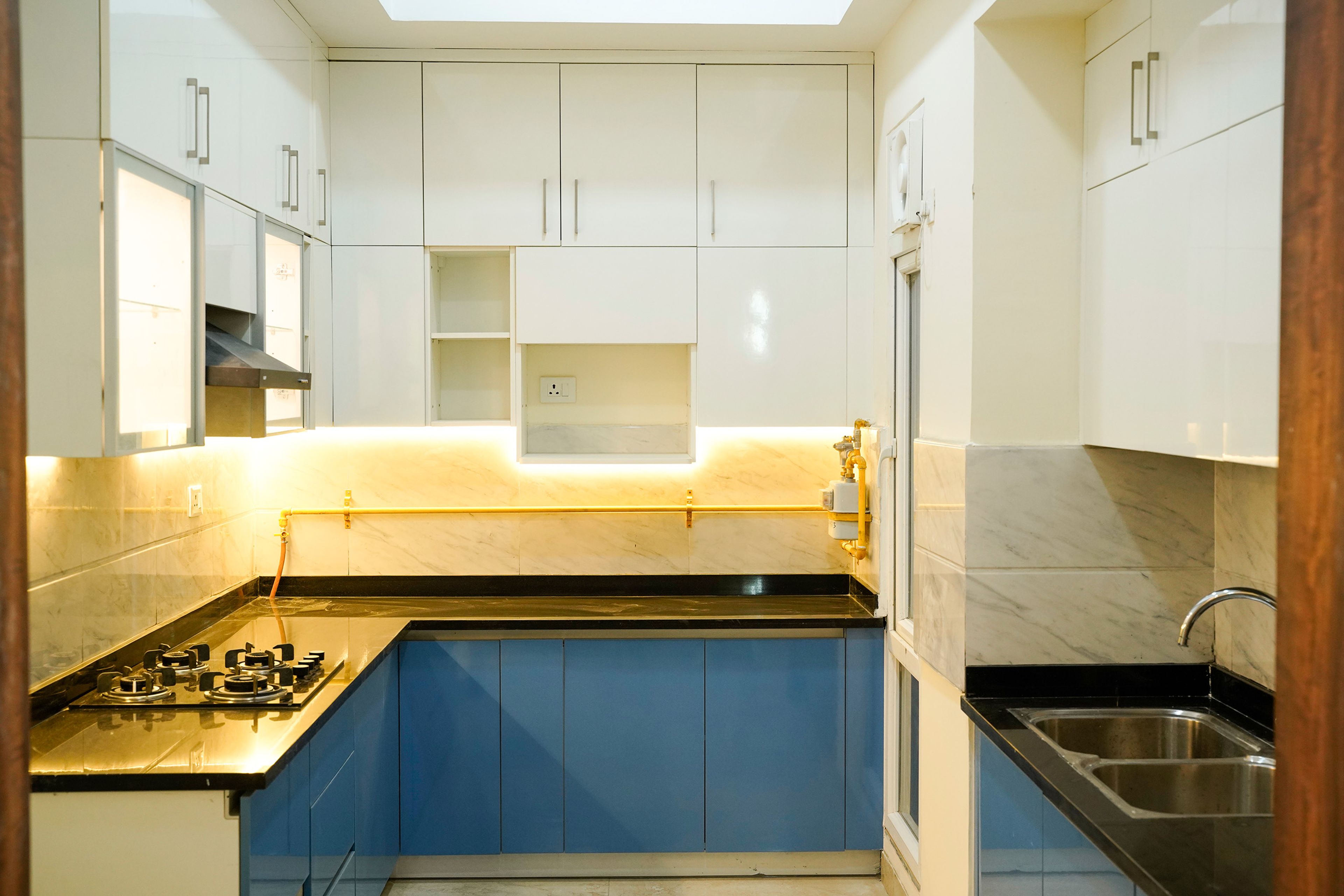 L-Shaped Kitchen Design with Under Cabinet Lighting and Blue and White Units