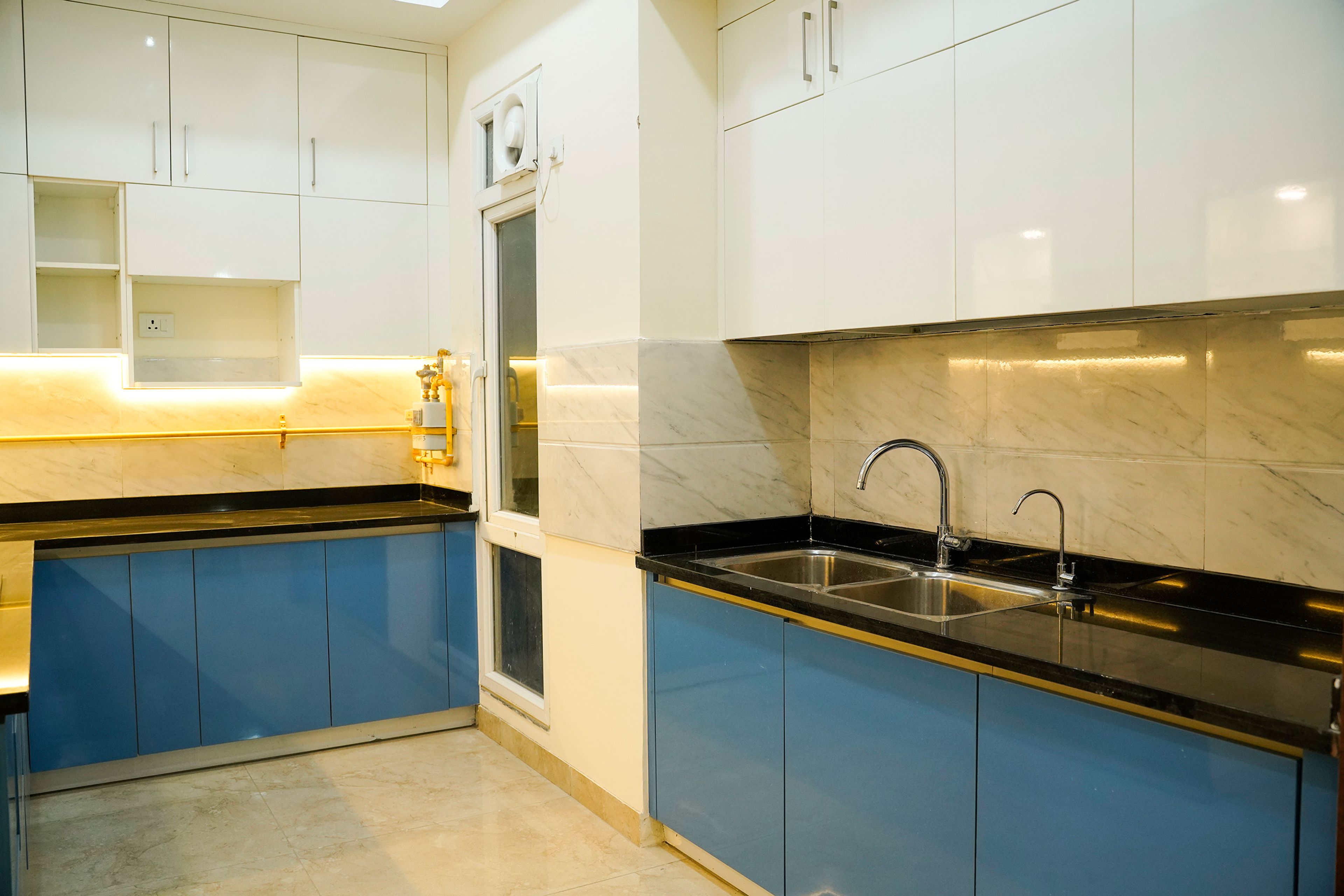 L-Shaped Kitchen Design with Under Cabinet Lighting and Blue and White Units