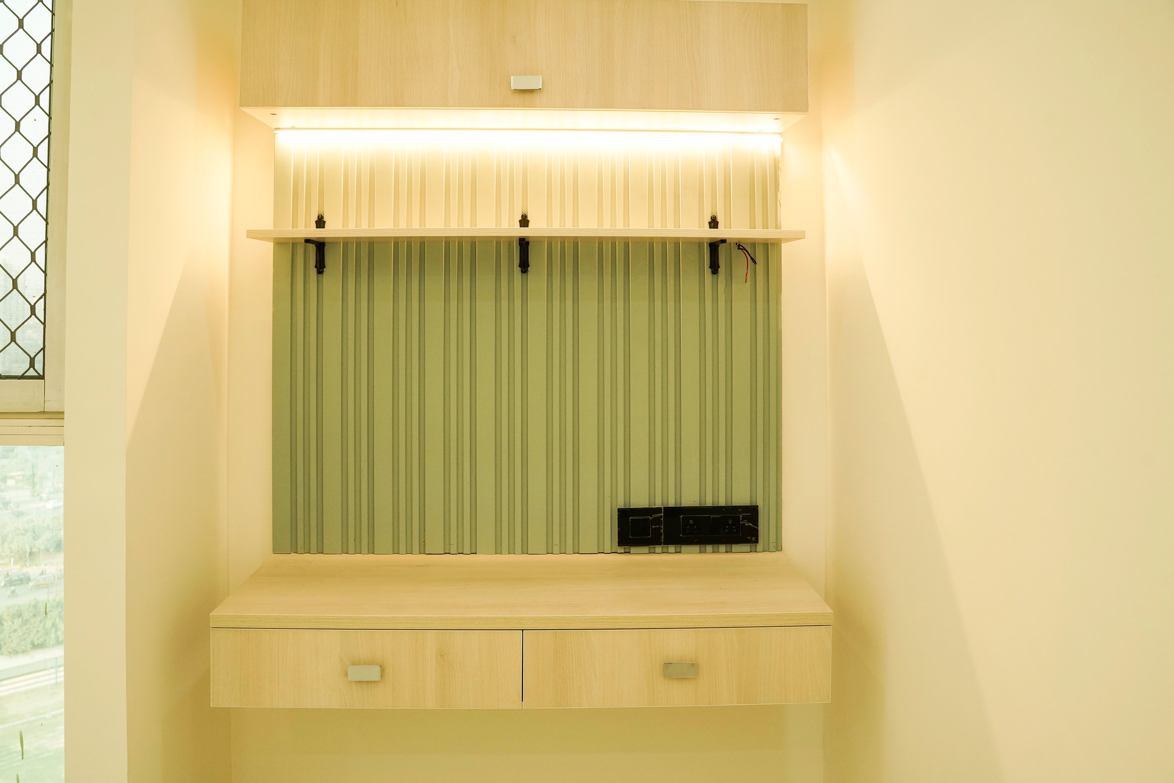 Cream TV Unit with green wall trims backsplash