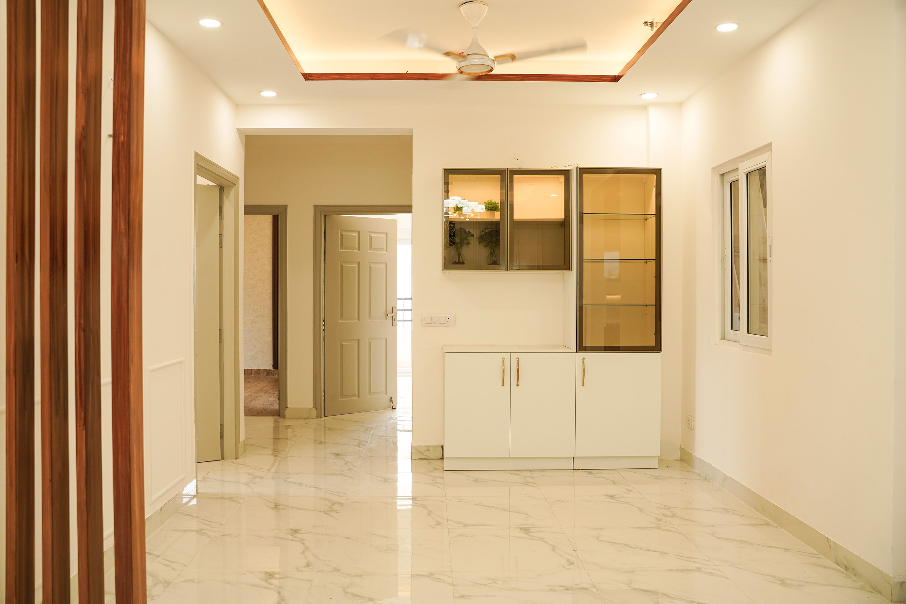 Dining Room Design with White and Glass Shutter Crockery Unit